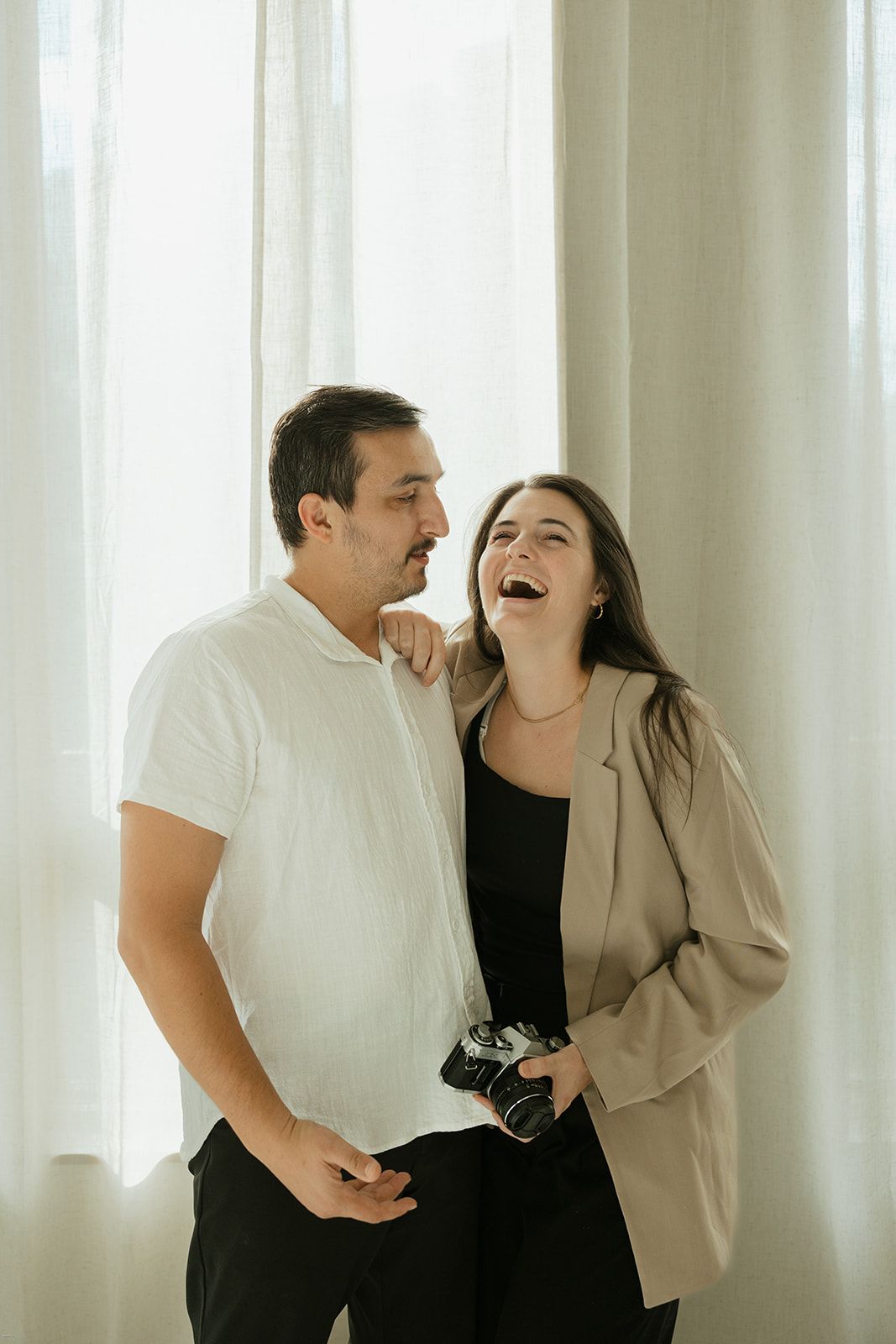 Katie and David Hevesi, Atlanta wedding photographers, smiling together indoors