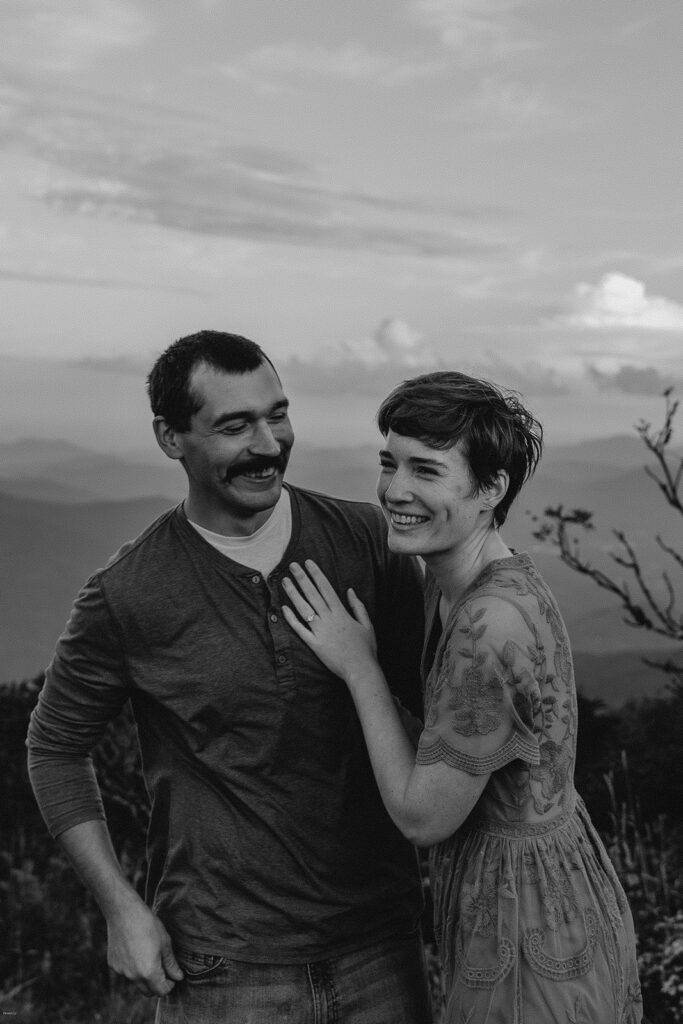 Laughing couple during an adventurous engagement session at Craggy Gardens