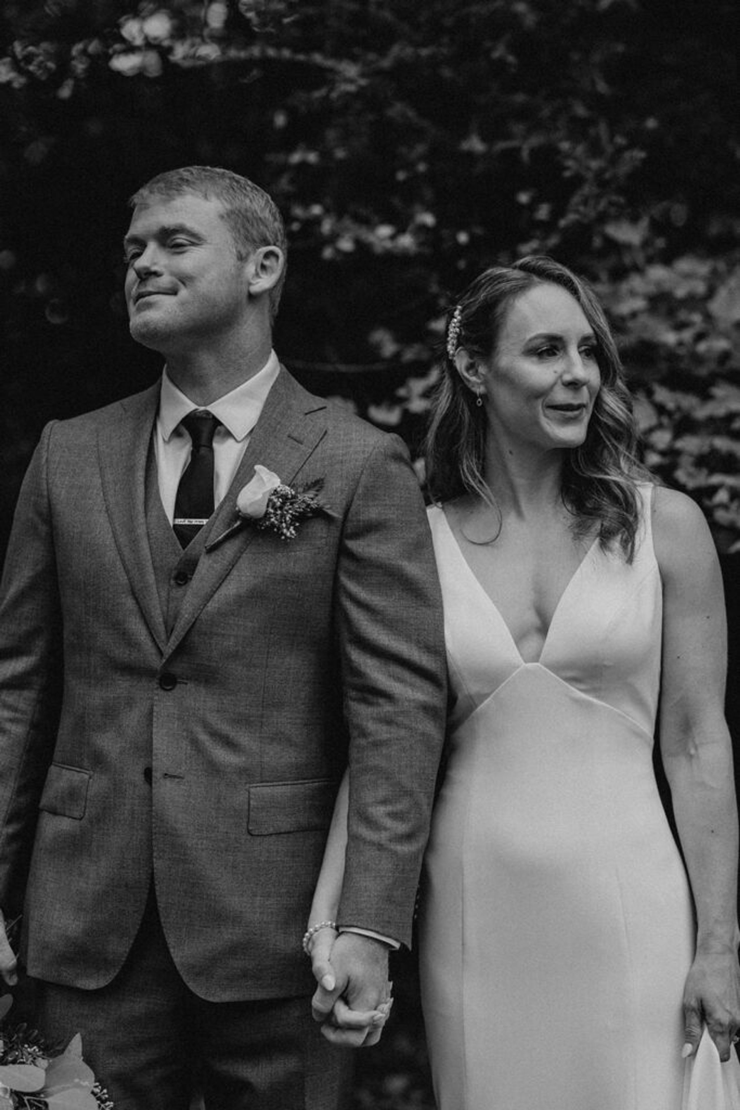 Scott and Deb walk hand in hand through the garden of 173 Carlyle House, with Scott smiling contentedly.