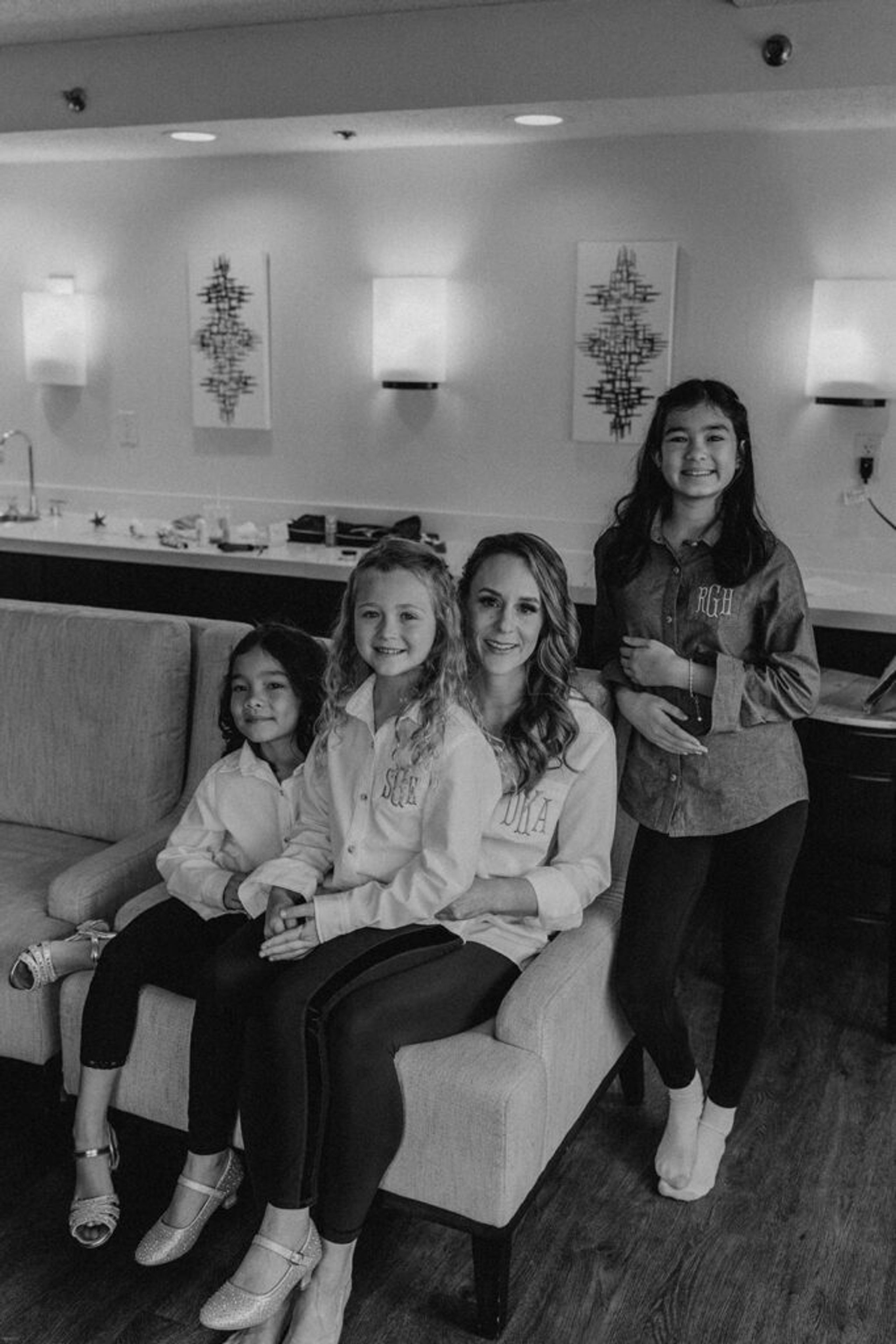 Deb sits with her bridesmaids and flower girls at 173 Carlyle House, enjoying a joyful moment before the ceremony.