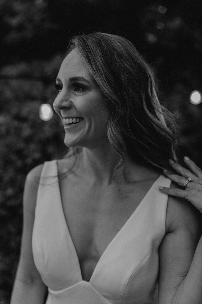 Deb smiles radiantly, enjoying a moment at 173 Carlyle House during the evening celebration