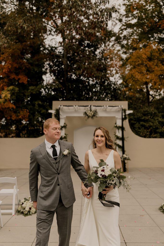 Scott and Deb walk hand in hand down the aisle after their ceremony at 173 Carlyle House.