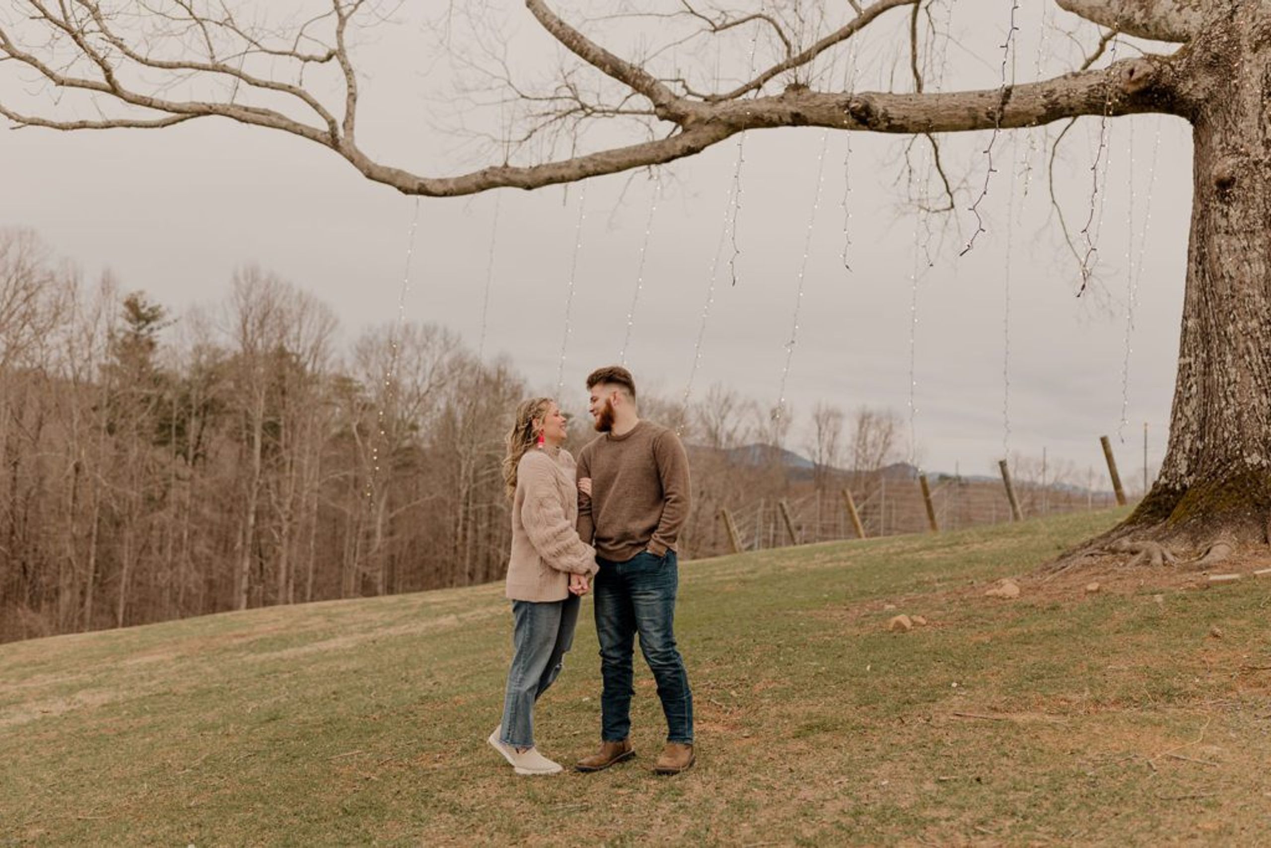 Taylor and Guillermo holding hands near the vineyard at Monteluce Winery, with views of the North Georgia mountains