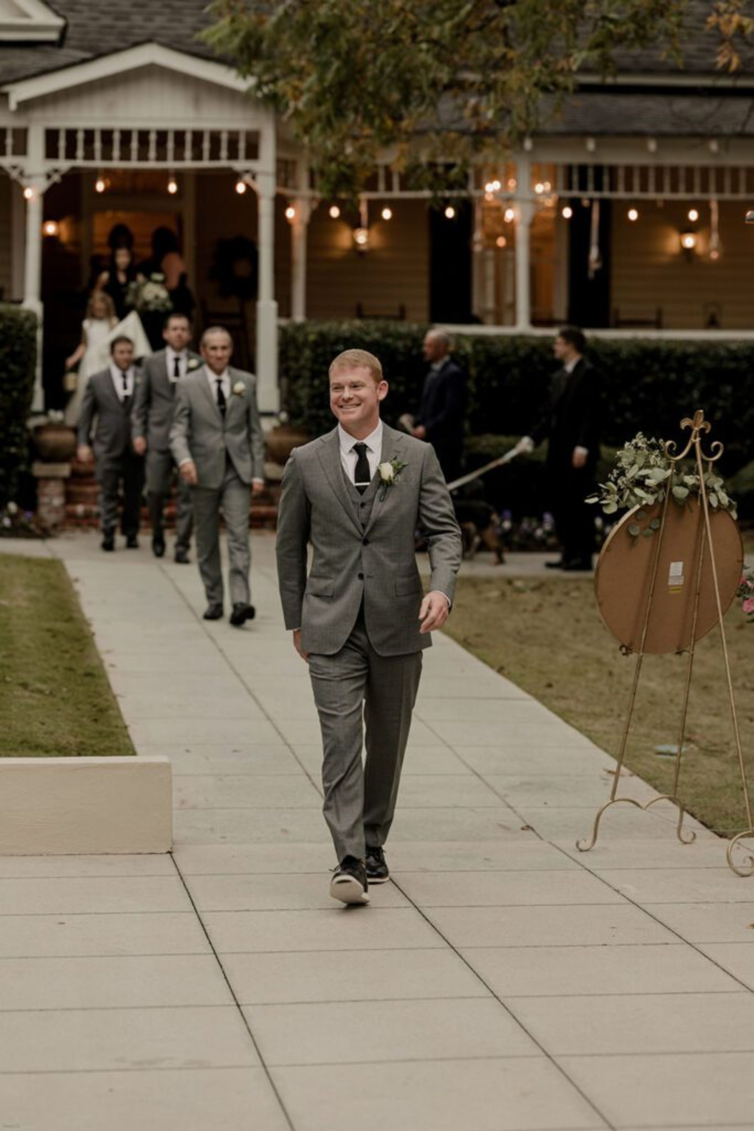 Scott walks down the aisle at 173 Carlyle House, smiling as he approaches the ceremony site.