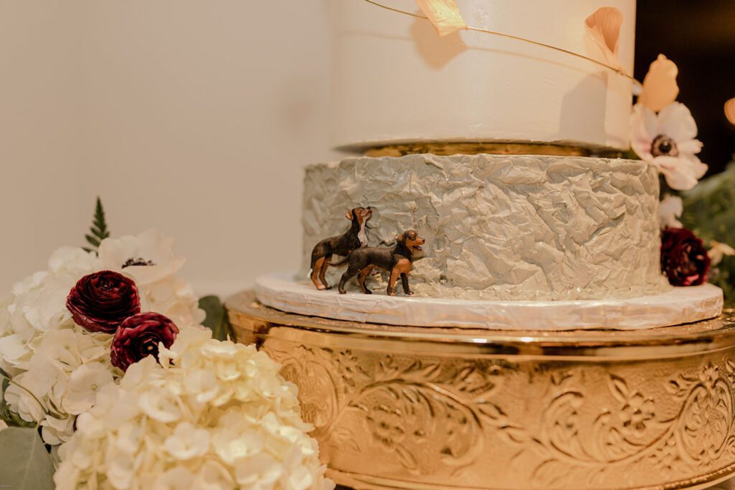 A close-up of the wedding cake, adorned with dog figurines as a personal touch at 173 Carlyle House.