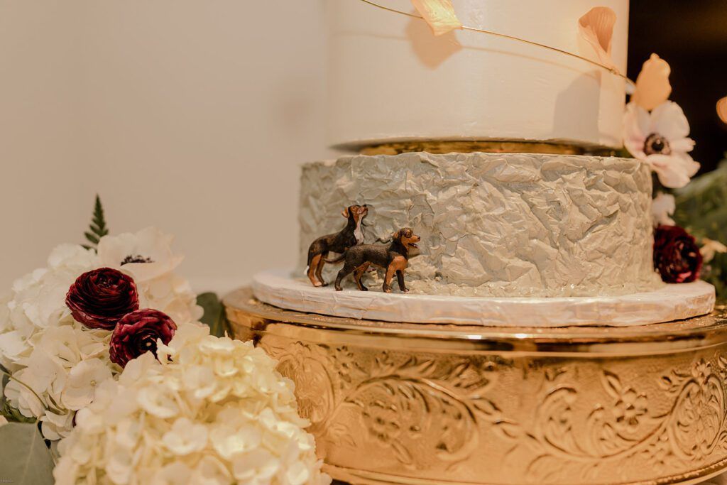 A close-up of the wedding cake, adorned with dog figurines as a personal touch at 173 Carlyle House.