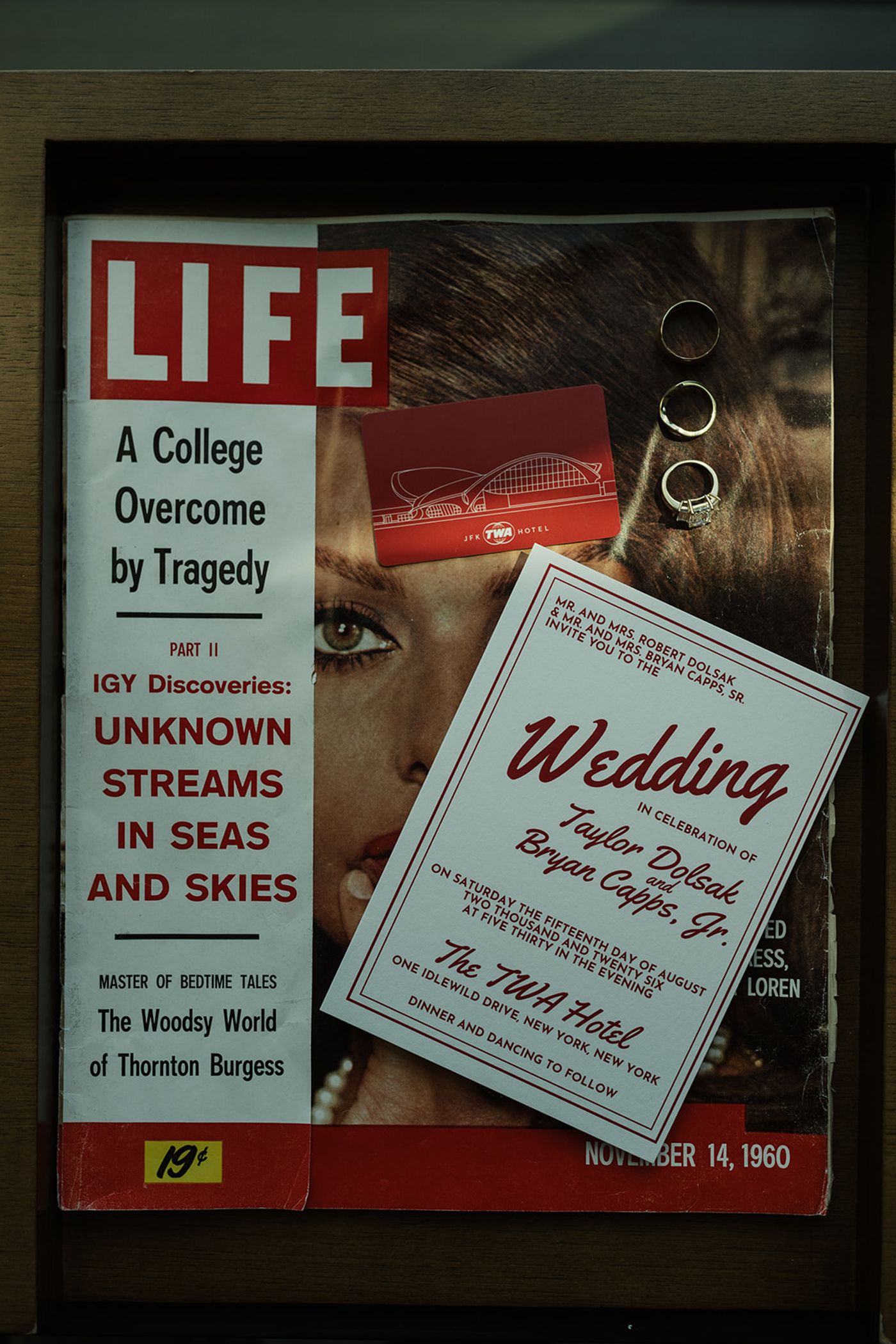 TWA Hotel wedding invitation and rings laid on a 1960 LIFE magazine