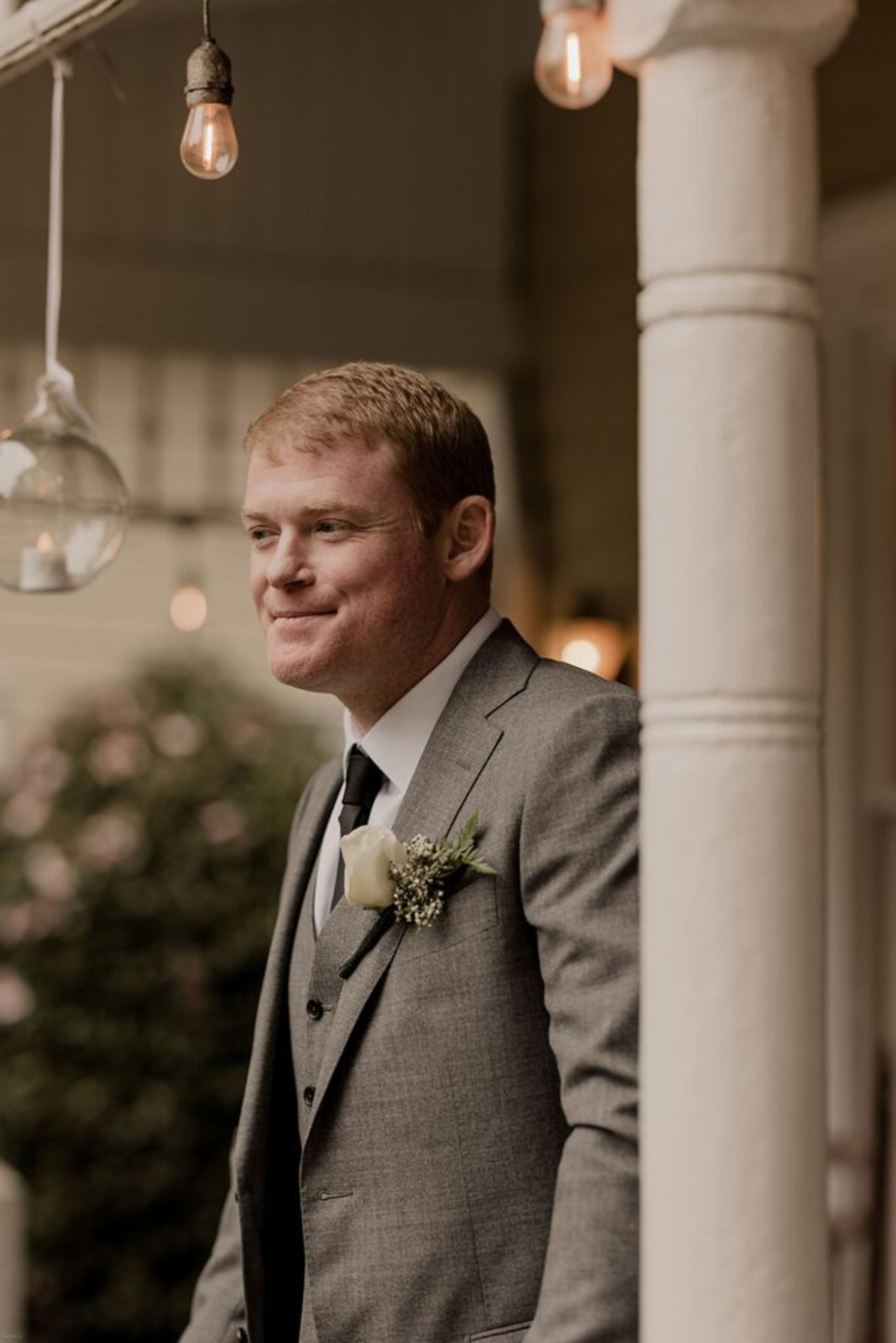 Scott smiles under the warm glow of porch lights at 173 Carlyle House, ready for the wedding celebration.