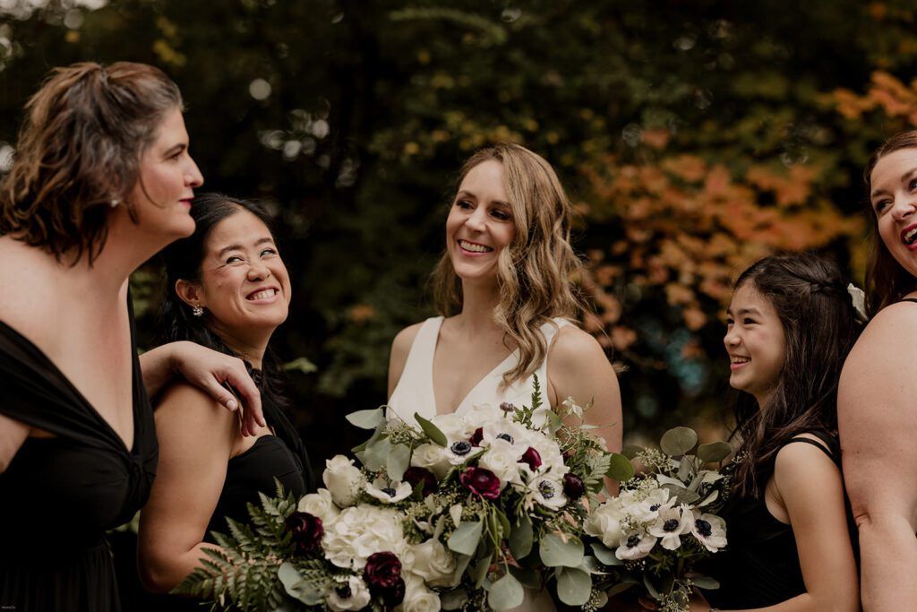 Deb beams with joy, holding her elegant bouquet of white and burgundy flowers at 173 Carlyle House.