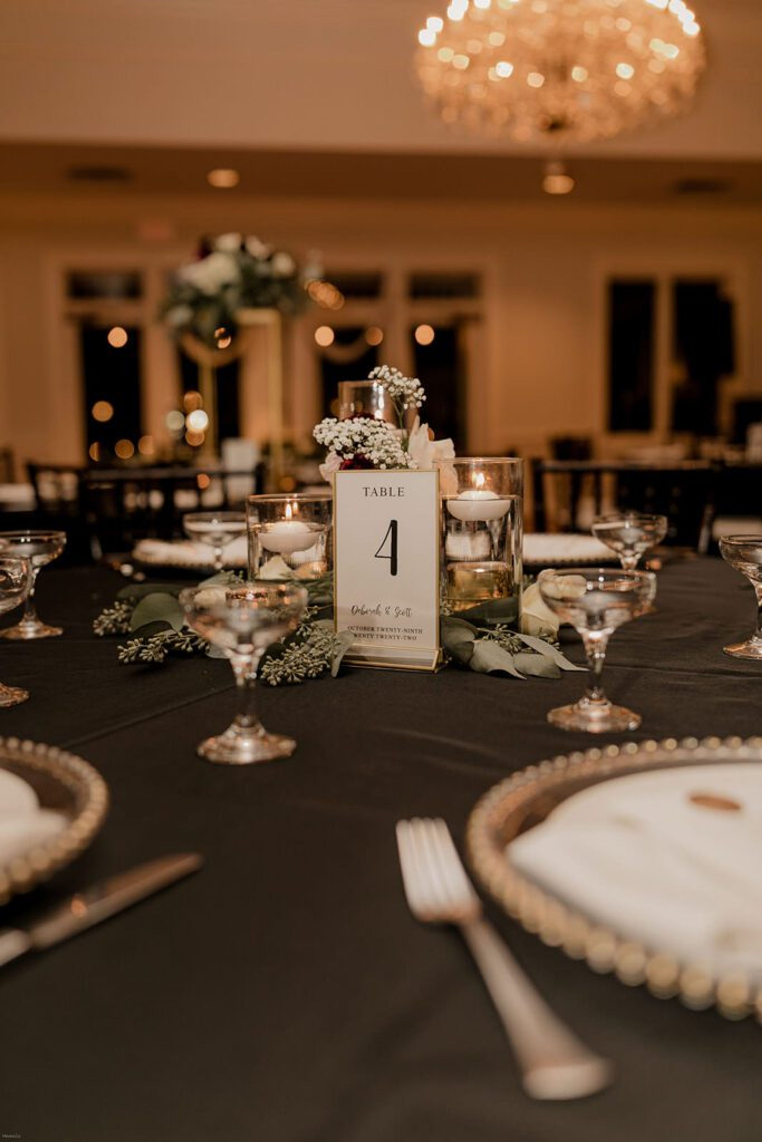 A detailed view of a table setting at the wedding reception at 173 Carlyle House, featuring a number card and elegant decor.