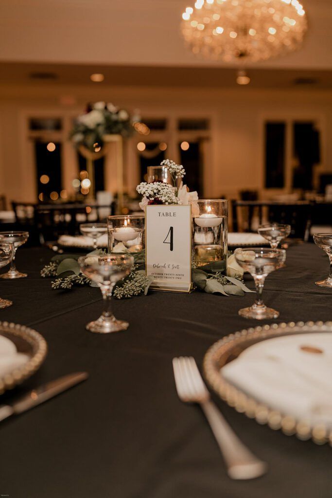 A detailed view of a table setting at the wedding reception at 173 Carlyle House, featuring a number card and elegant decor.