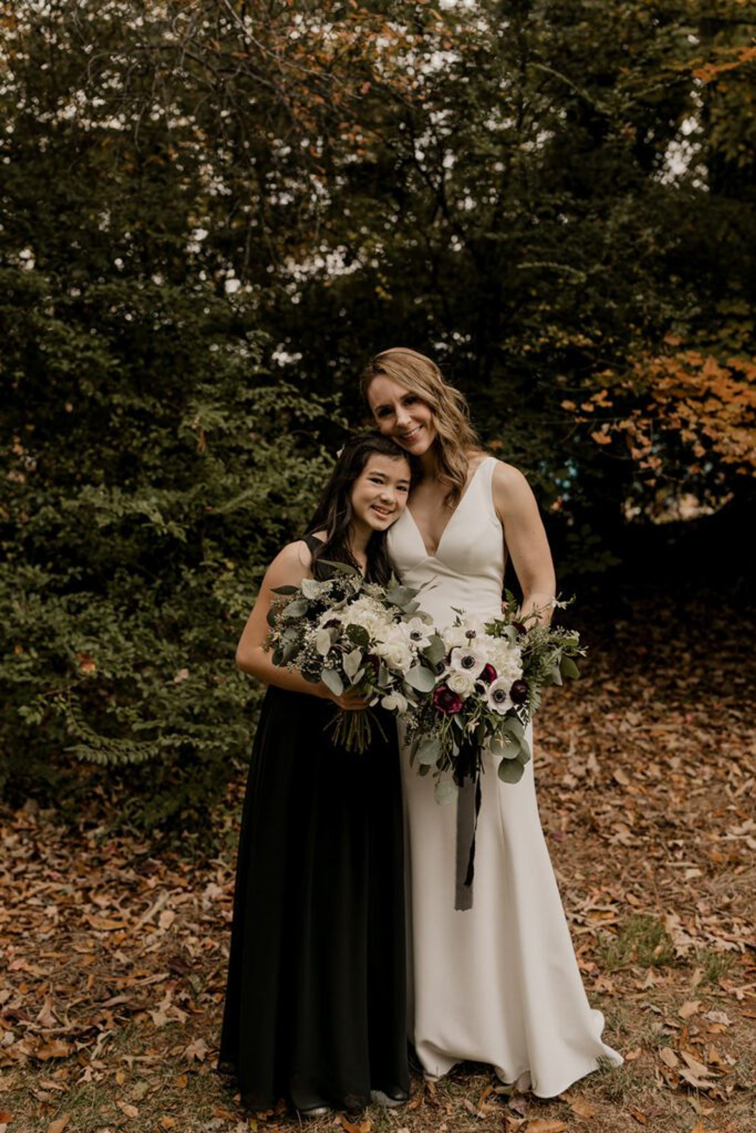 Deb and one of her bridesmaids pose together, smiling with their bouquets at 173 Carlyle House."