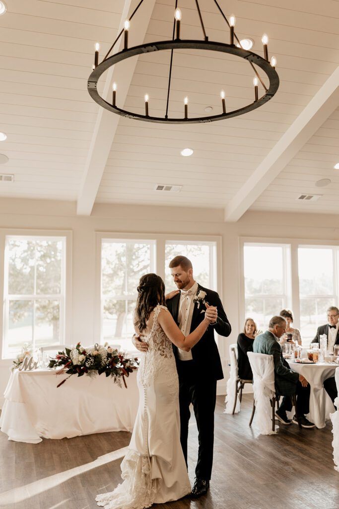 Bride and groom sharing their first dance in a bright reception hall at Chimney Oaks Golf Club