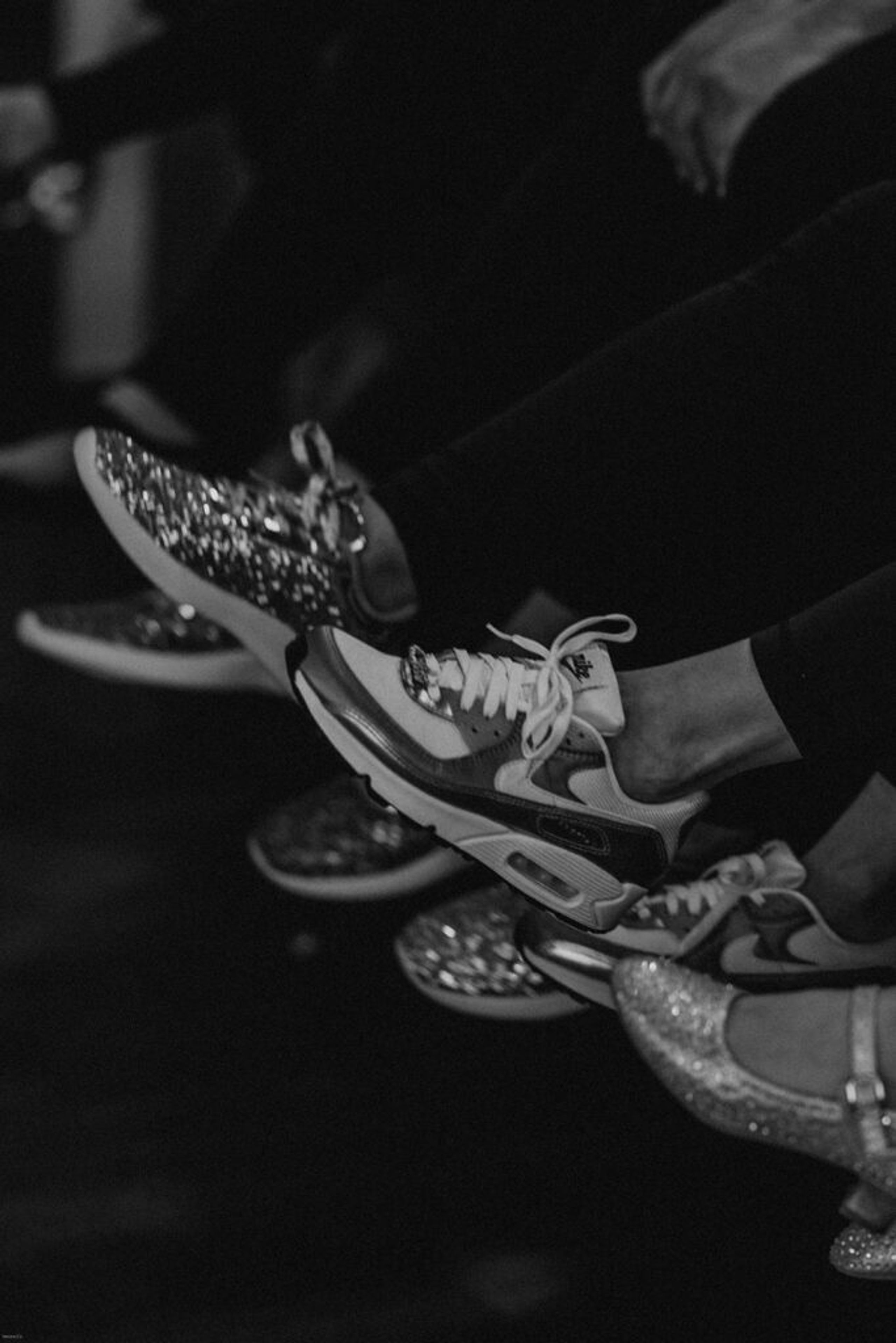 A close-up shot of wedding guests' feet, showing an array of sparkling and stylish shoes, capturing a fun and relaxed moment.