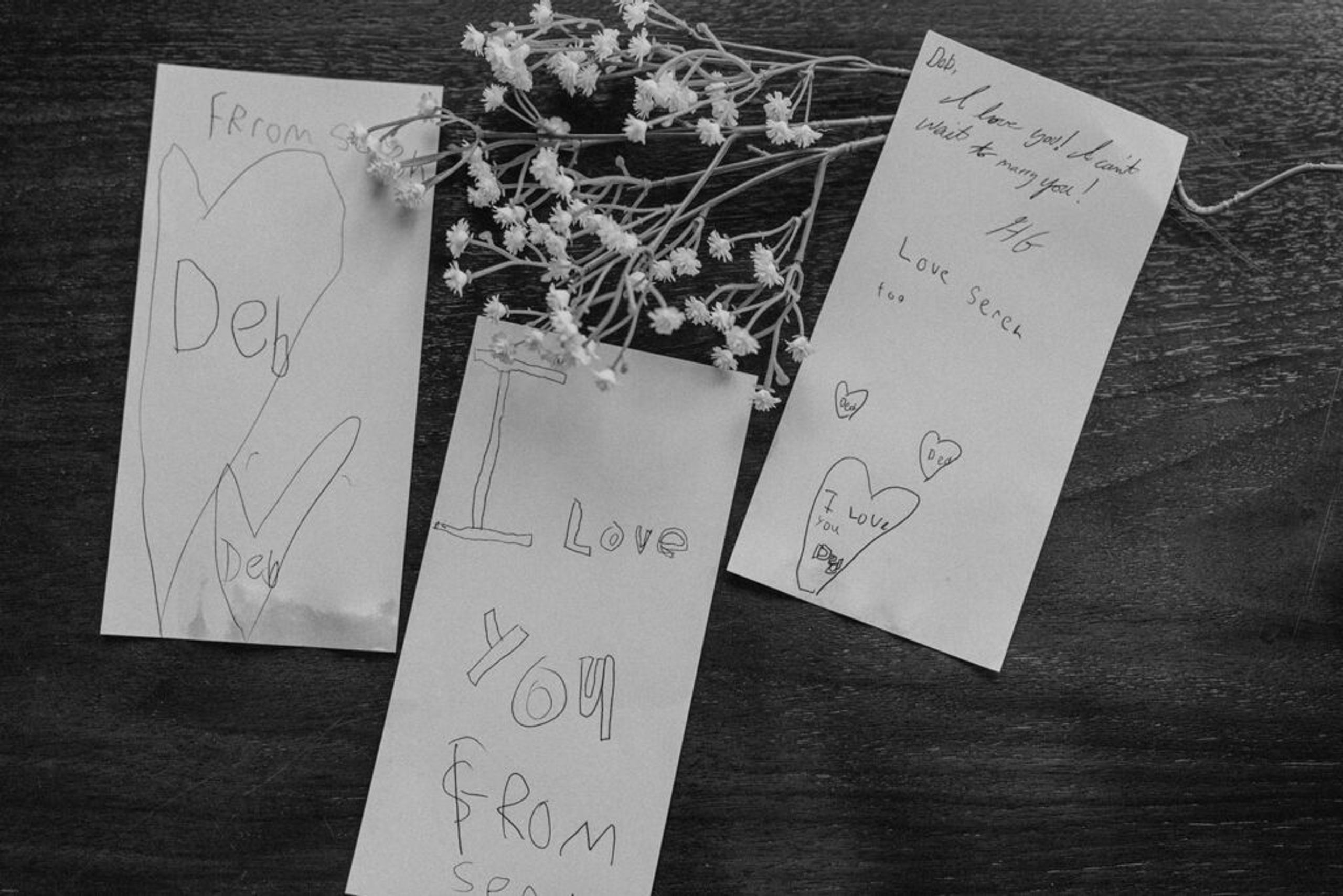 A close-up of handwritten notes with loving messages, accompanied by delicate flowers at 173 Carlyle House.
