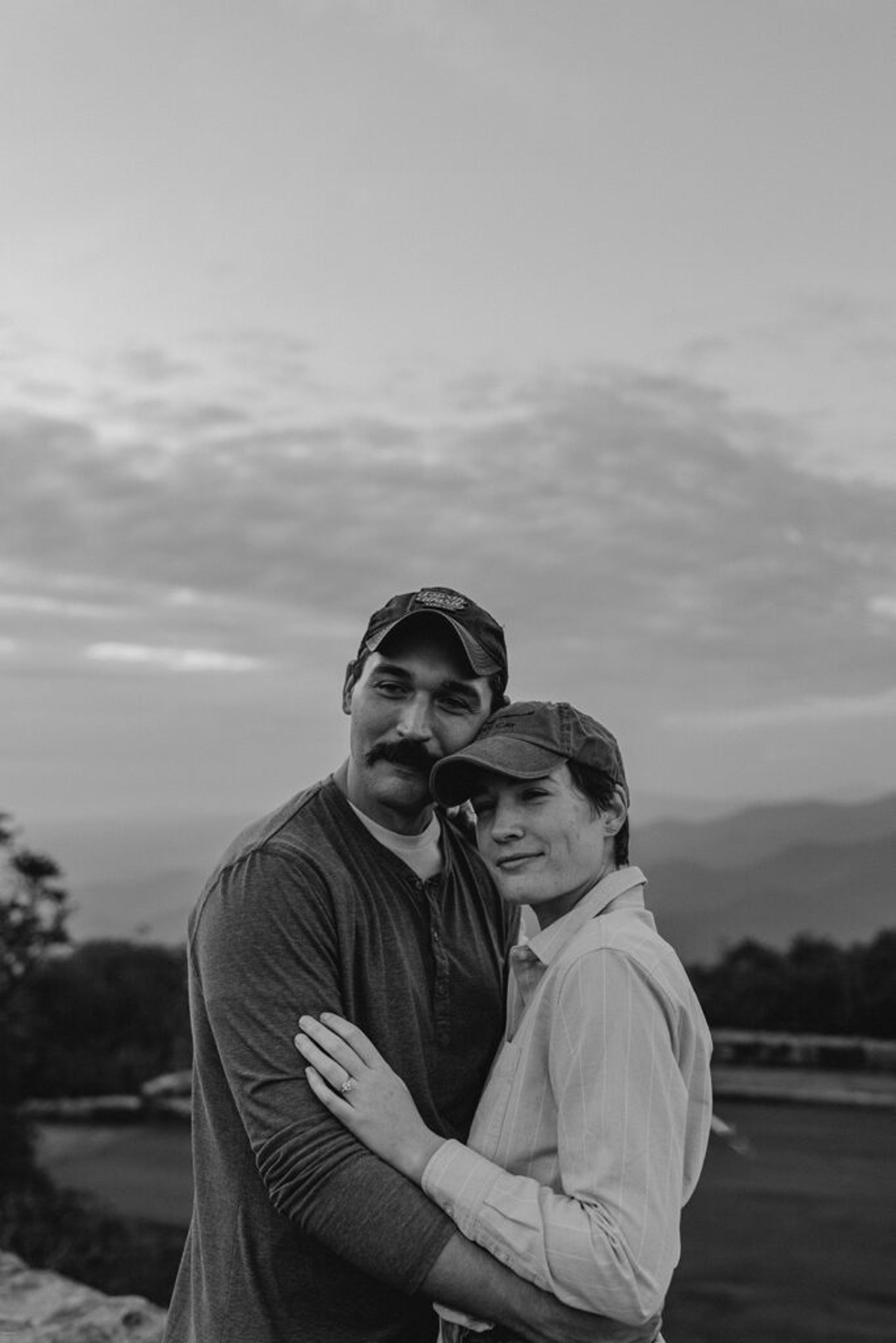 Couple embracing with mountain views during their Craggy Gardens engagement session at golden hour.