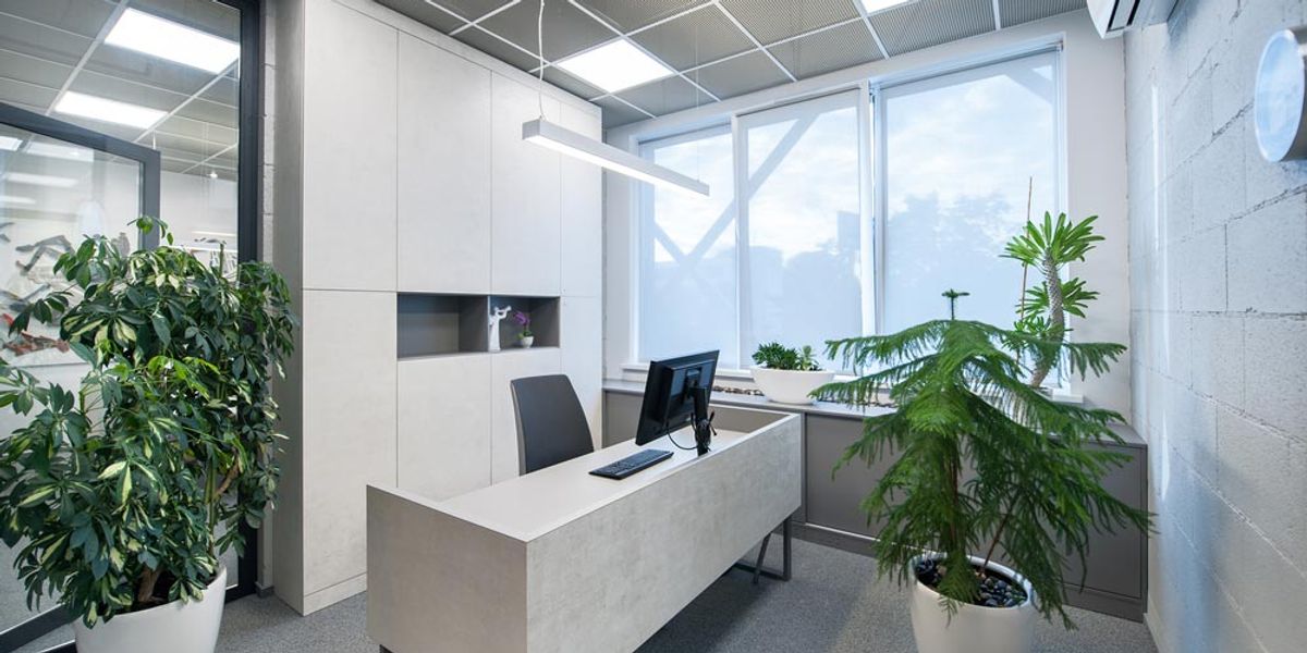 An office lit by LED panels, with a wall-mounted air conditioner
