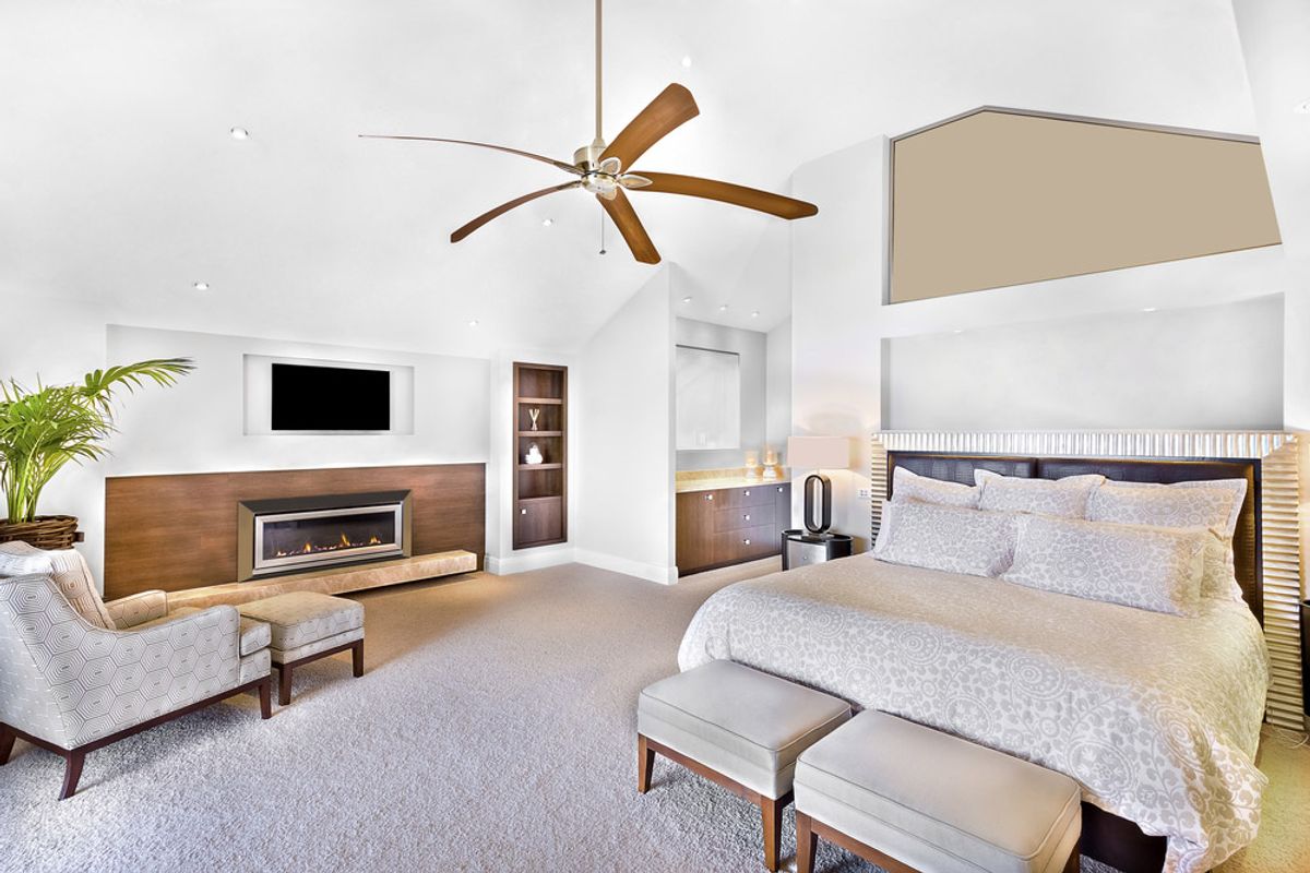 A timber-bladed ceiling fan on the raked ceiling of an open-plan living room