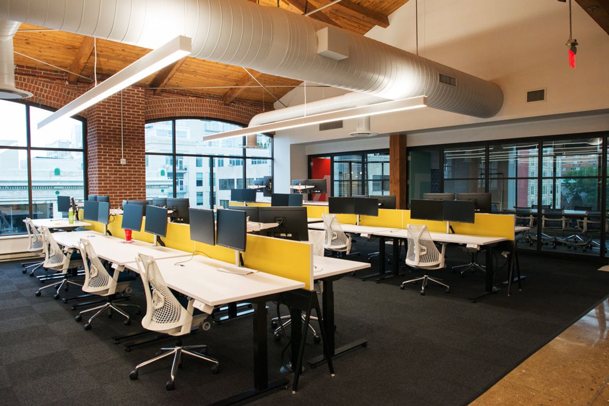Linear pendant lighting above desks in an open-plan office