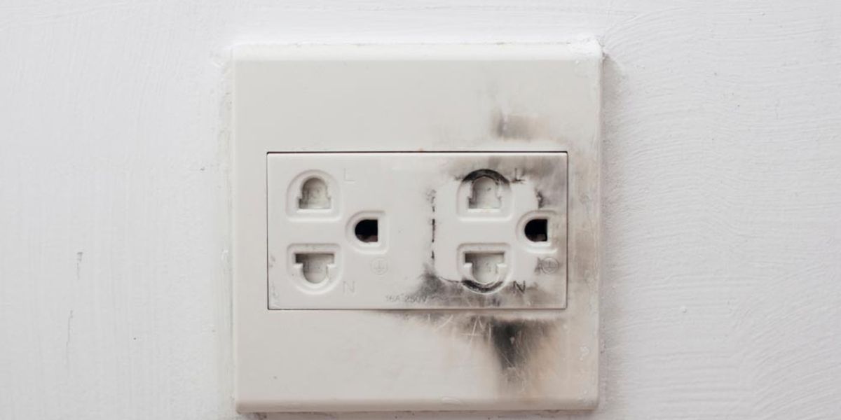 Black scorch marks around a wall power outlet