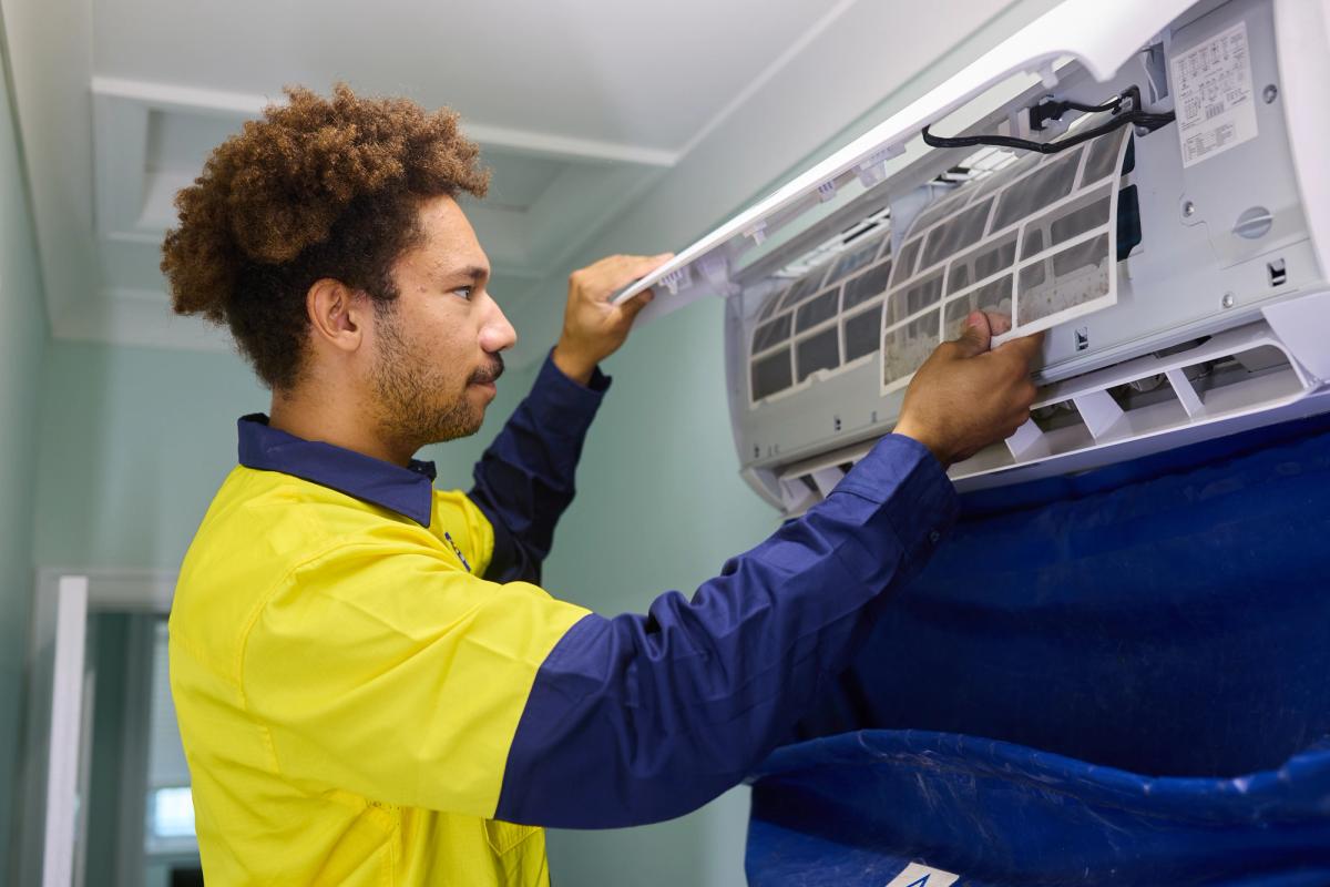 An O’Brien technician removing the filter from a wall-mounted air conditioner