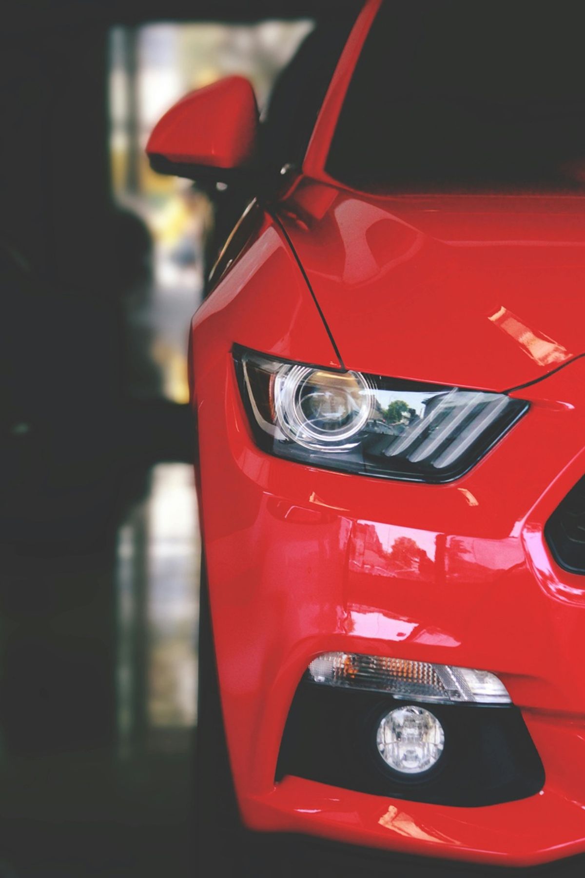 The front of a red car in a commercial car wash bay