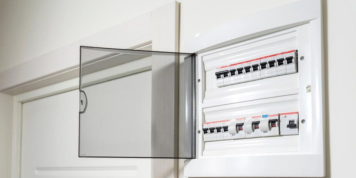 An open switchboard on a hallway wall showing rows of safety switches