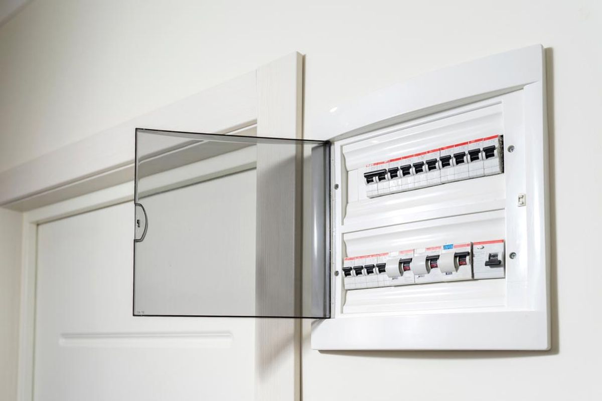 An open switchboard on a hallway wall showing rows of safety switches
