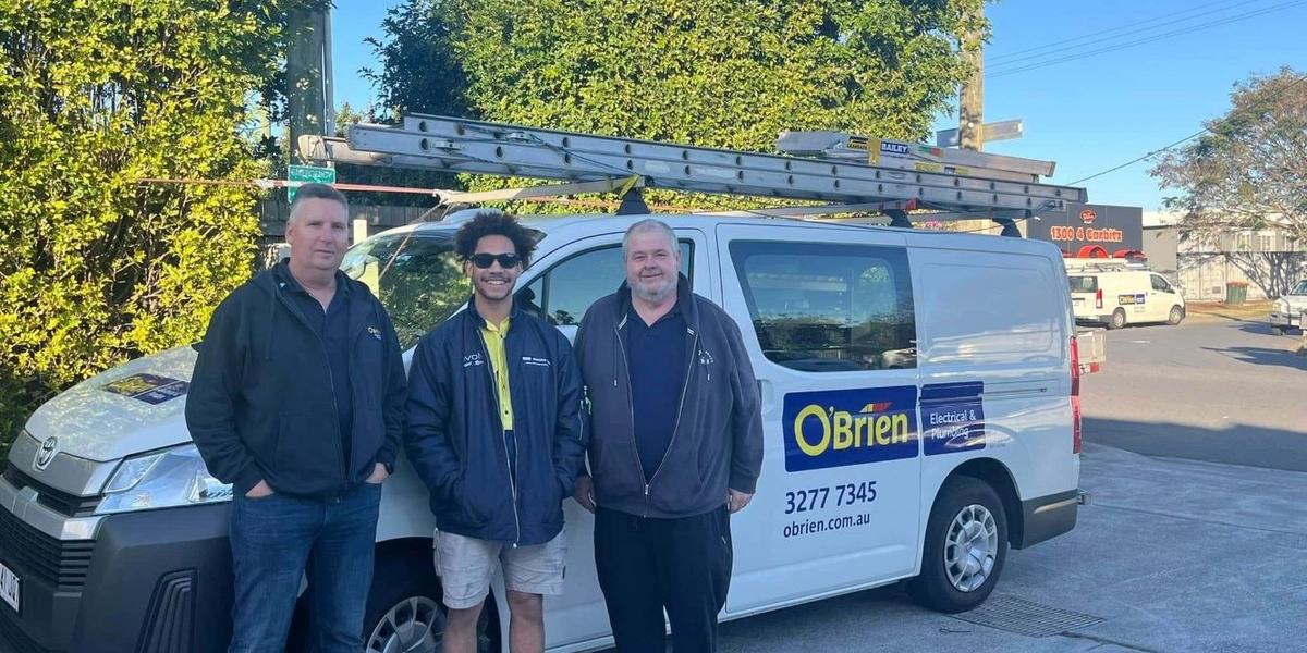 Three team members standing beside an O’Brien work van