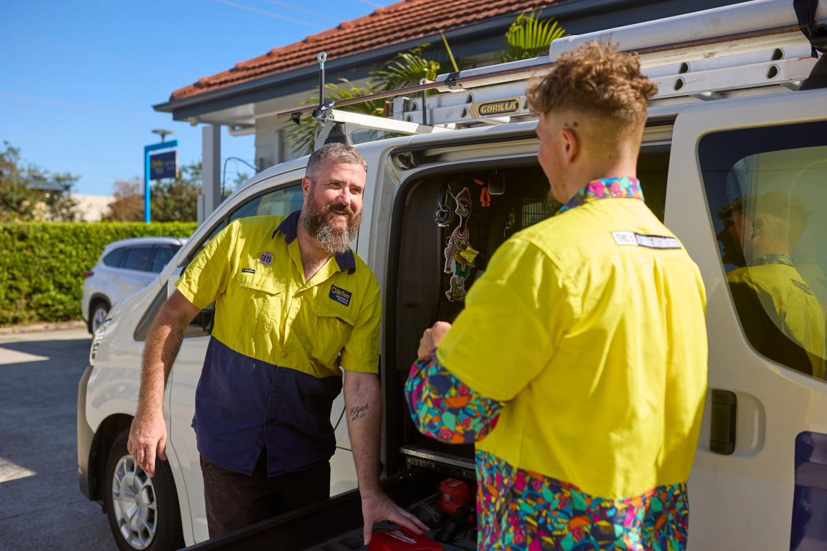 Two O’Brien technicians talking at the open back of a work van