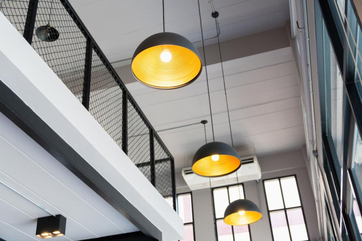 Black dome pendant lights hanging in a double-height stairwell