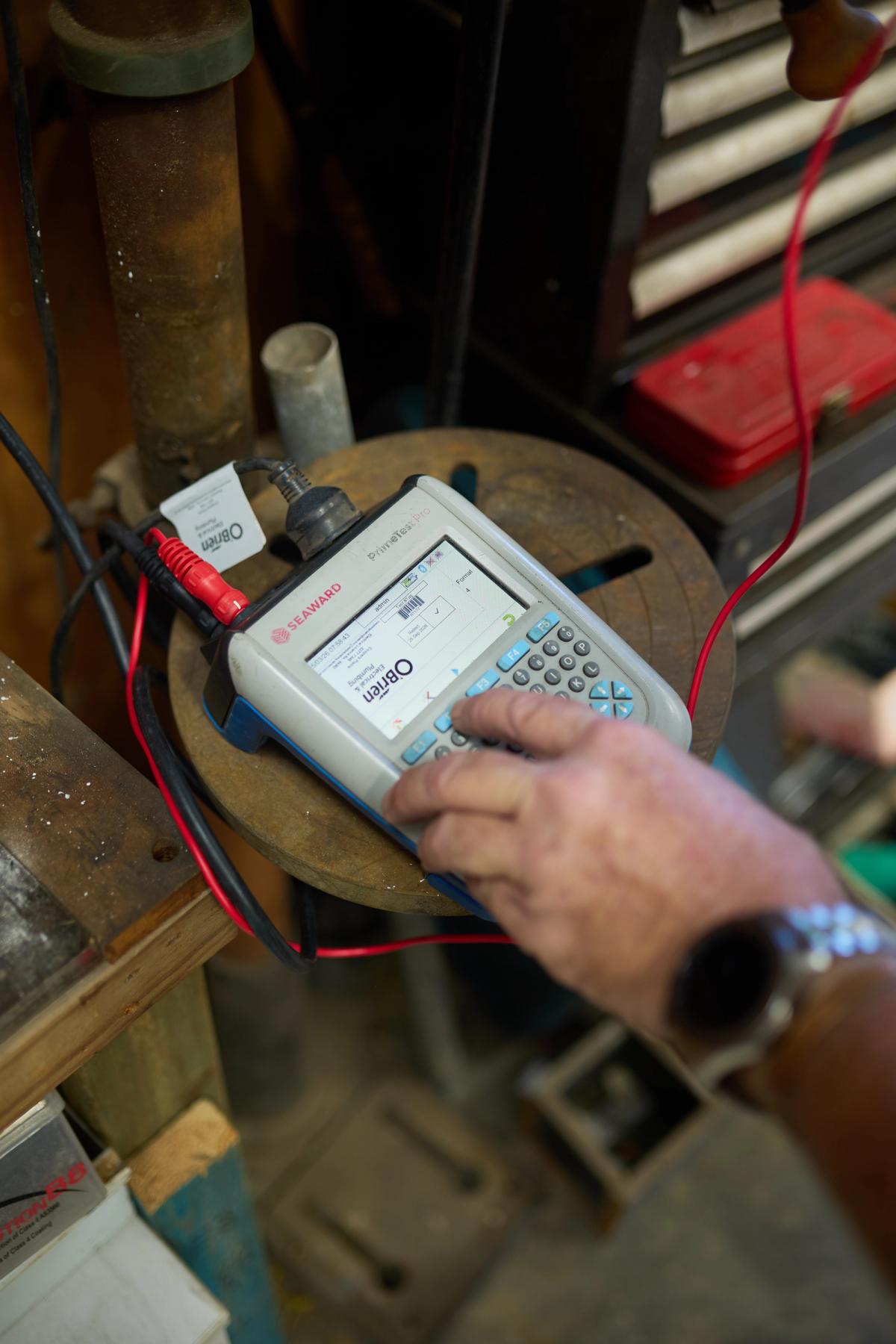 A technician using a test instrument on pipework