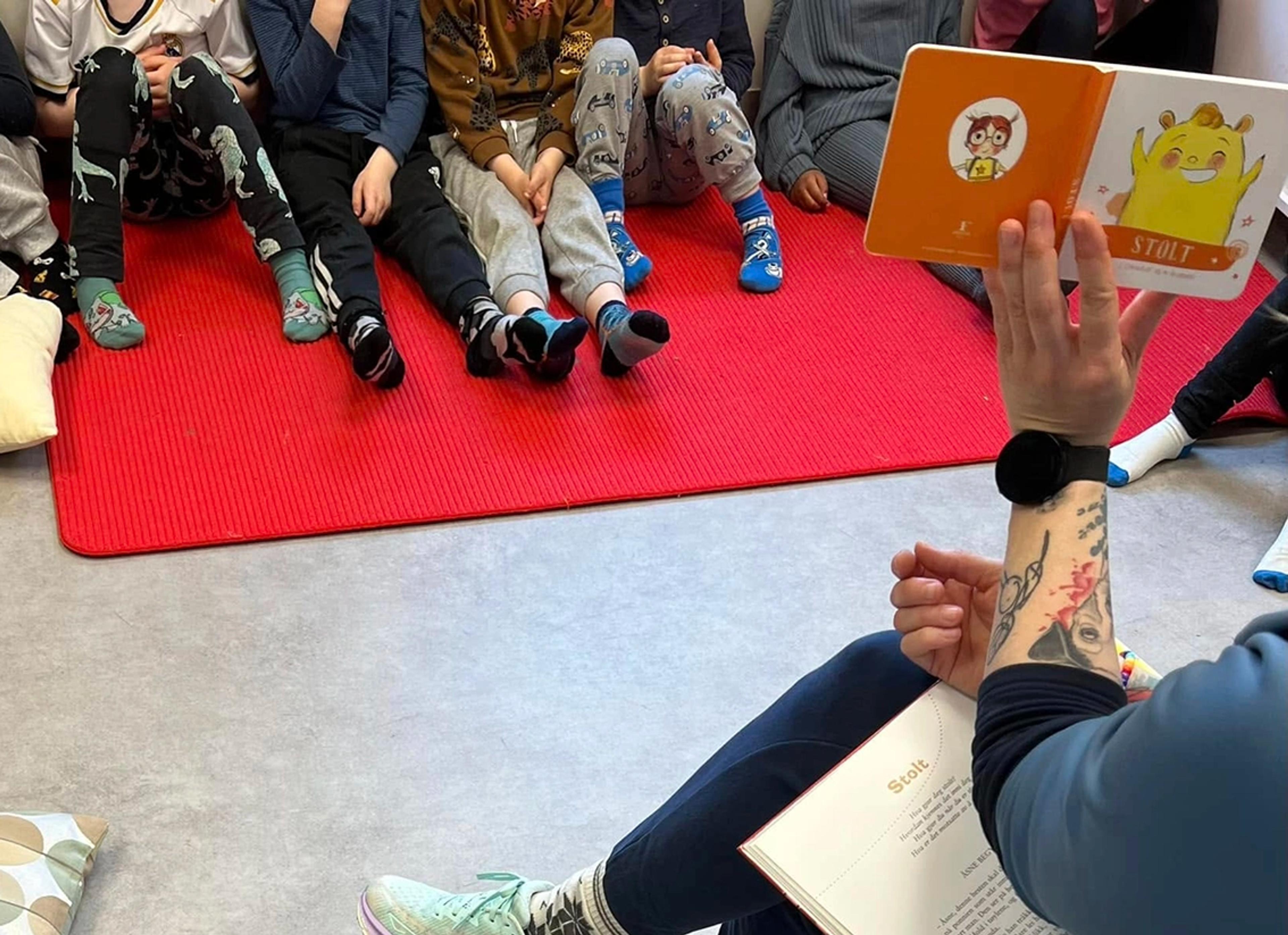 Ansatt som leser bok med barn i Espira Gjemble