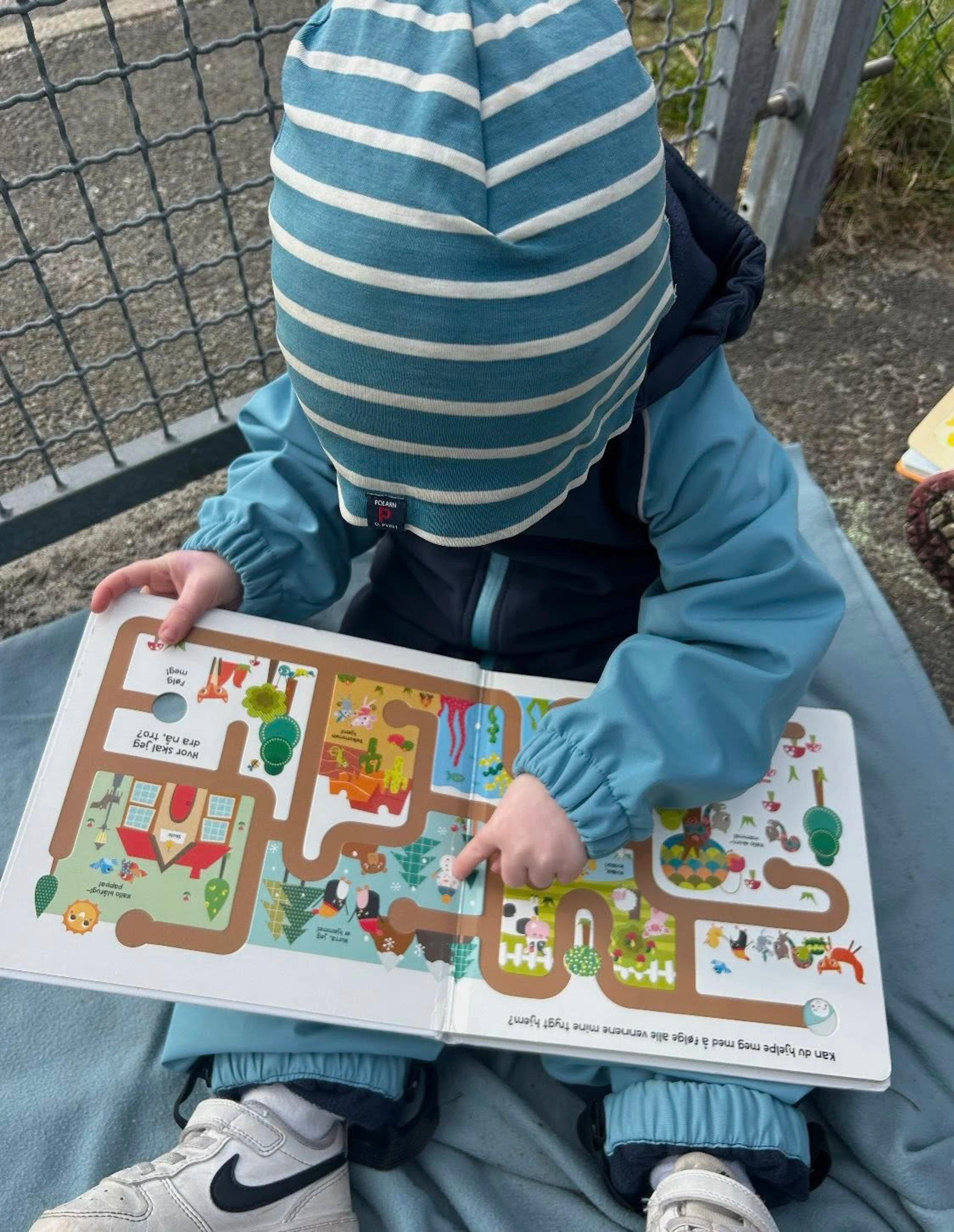 Barn som leser bok ute i Espira Stongafjellet