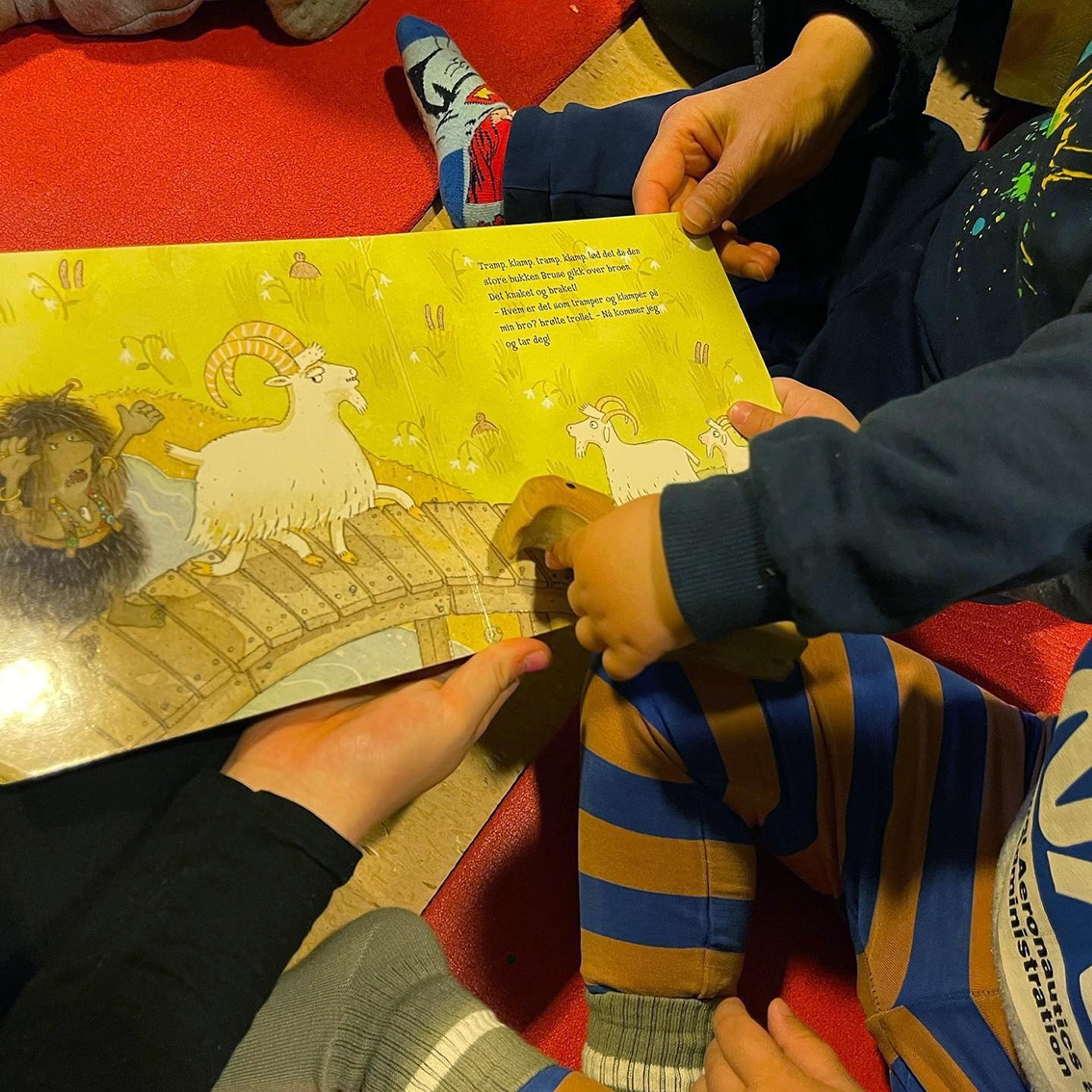 Barn som leser bok sammen med ansatt