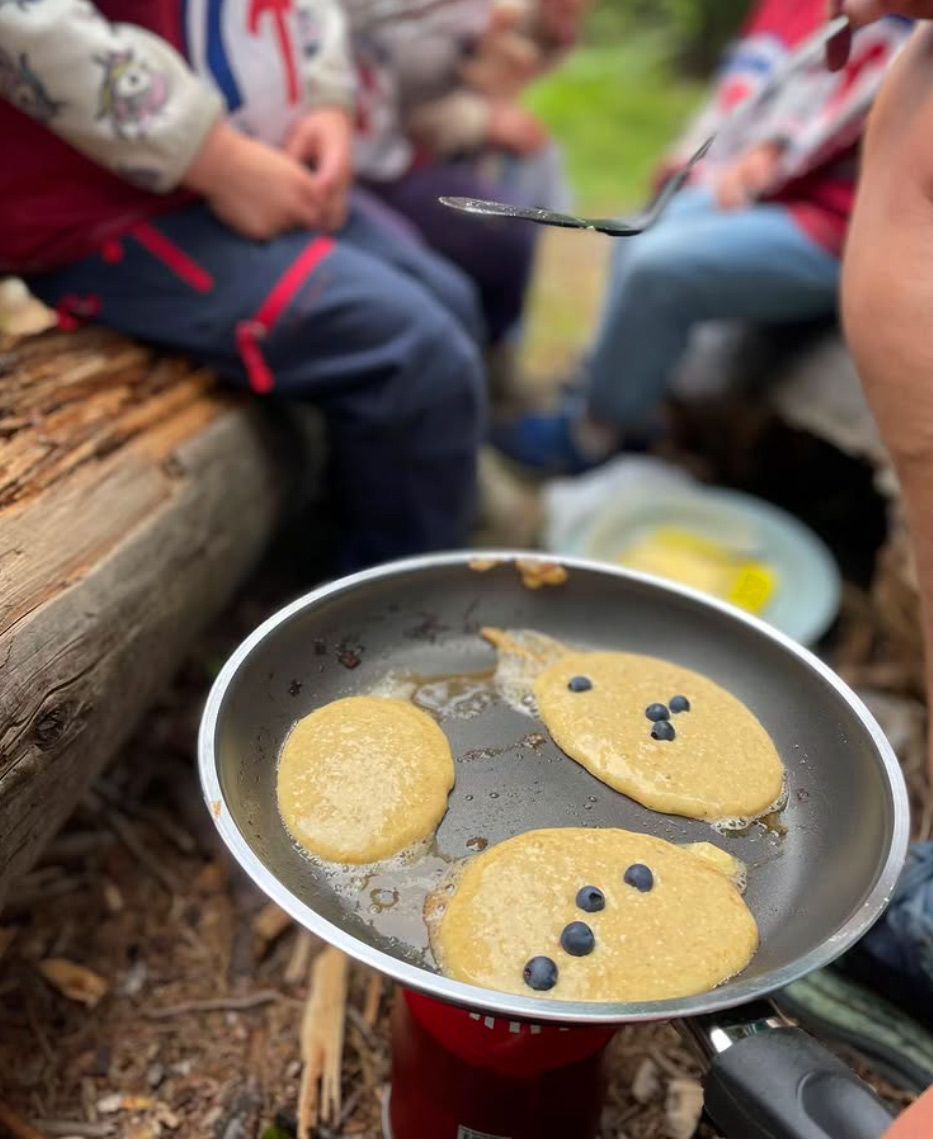 Pannekaker stekes på bål av barna på Tomm Murstad friluftsbarnehage