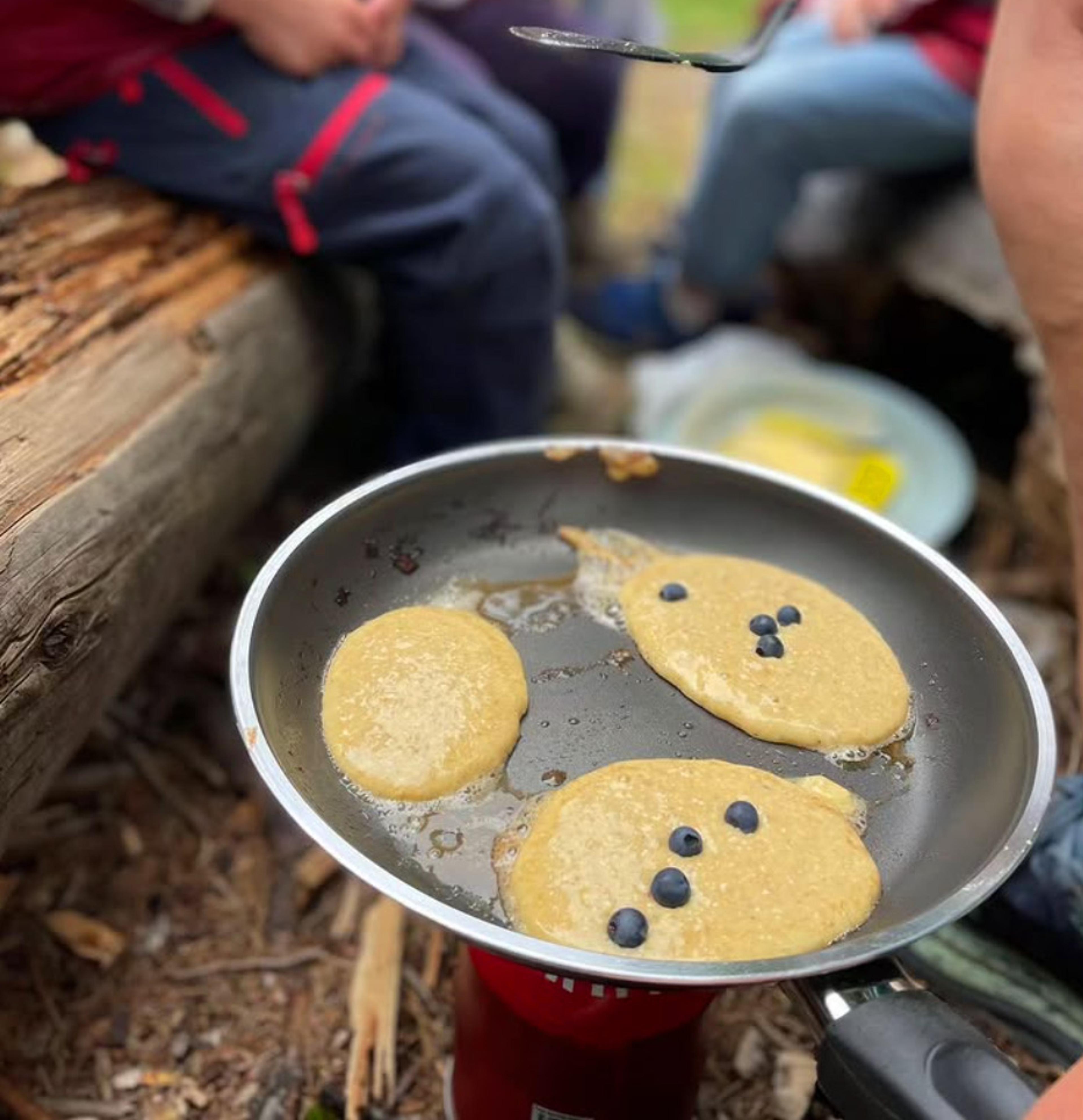 Pannekaker stekes på bål av barna på Tomm Murstad friluftsbarnehage