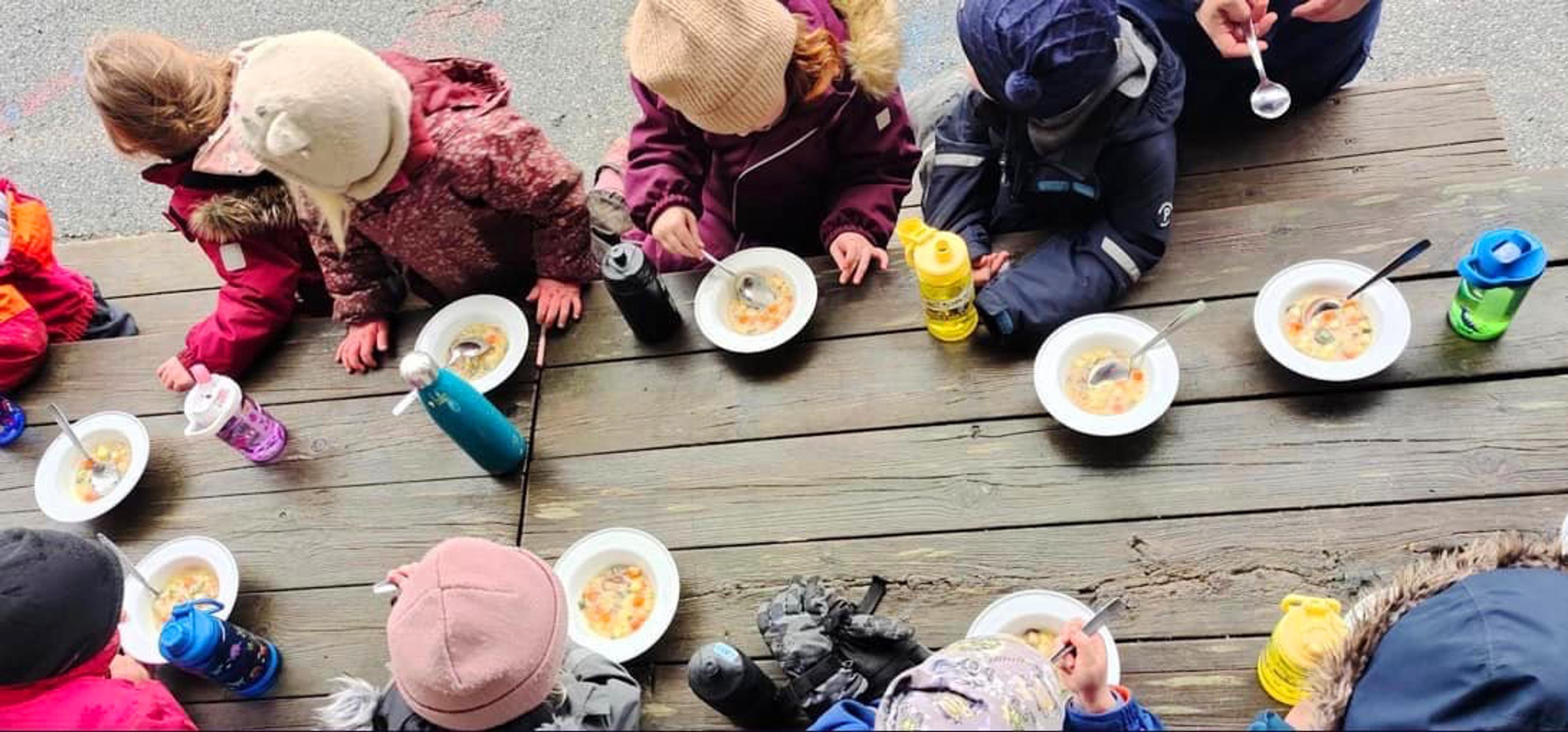Barn spiser måltid ute i Espira Veldetun