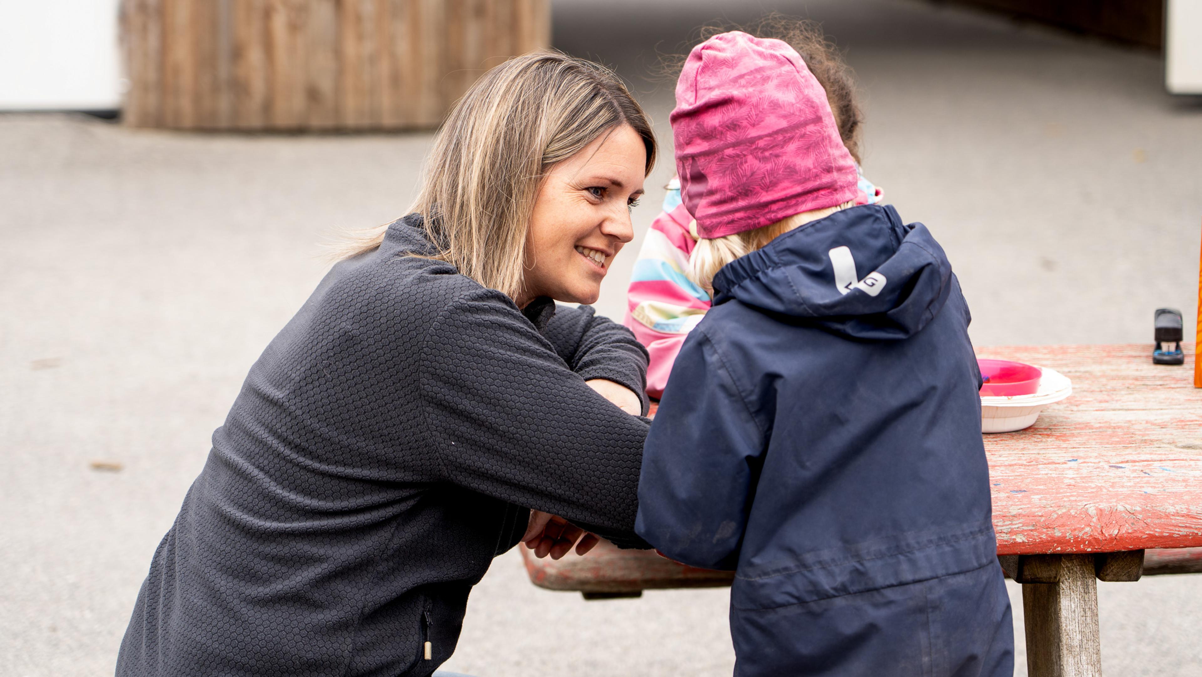 Hilde sammen med et barn utenfor Espira Hollund.