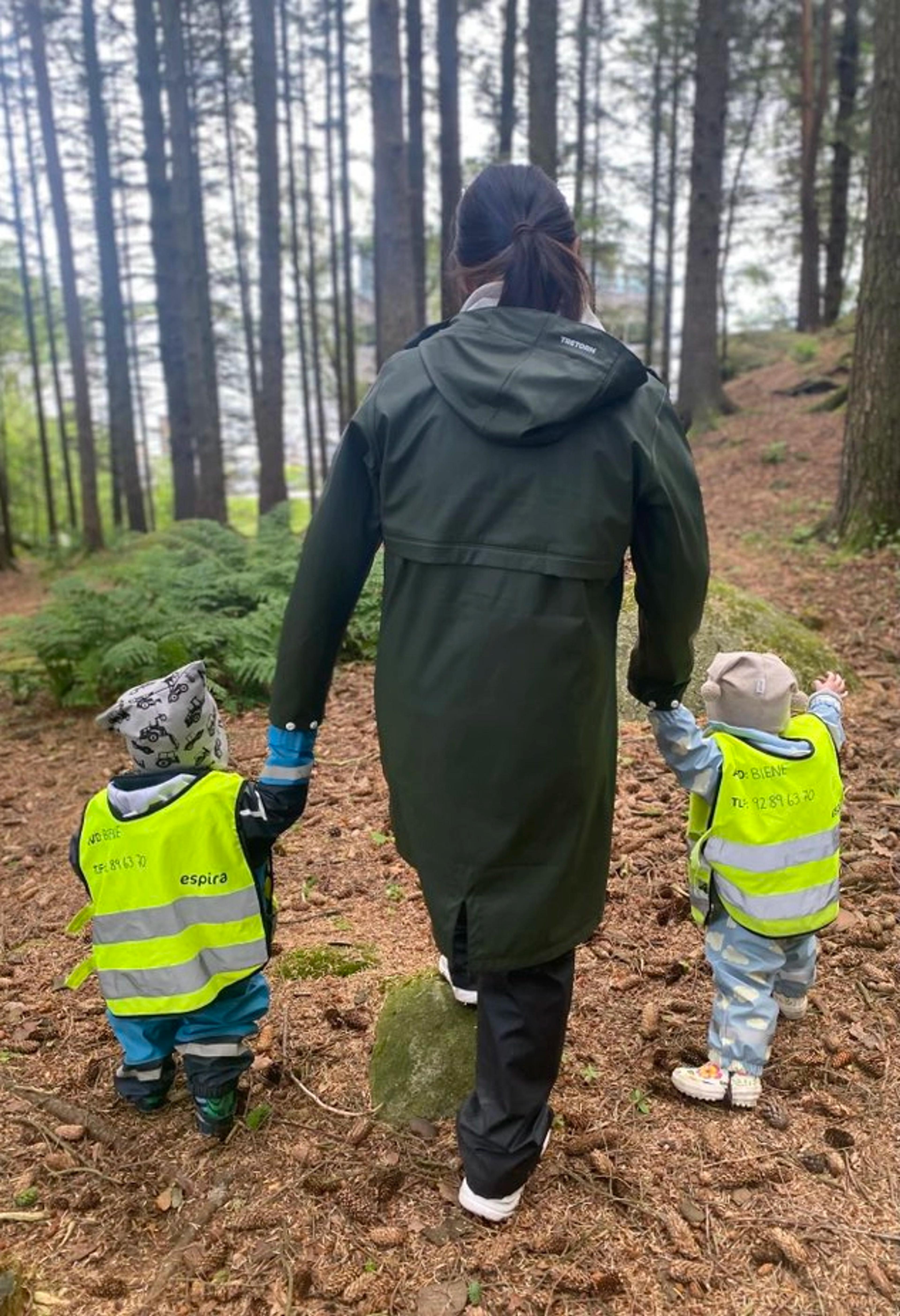 Ansatt og barn som går på tur i skogen