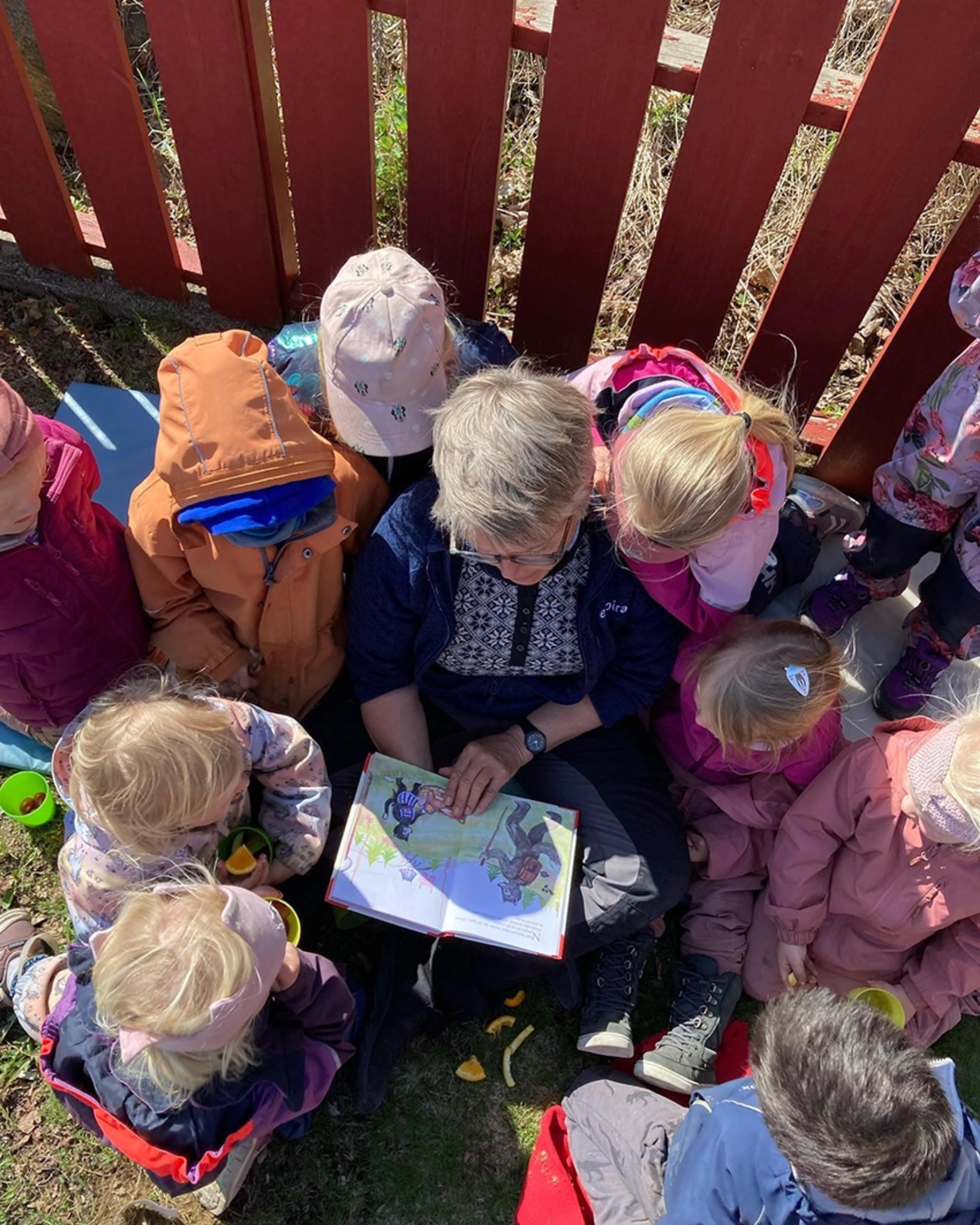 Ansatt som leser bok for barn i Espira Aarkjær