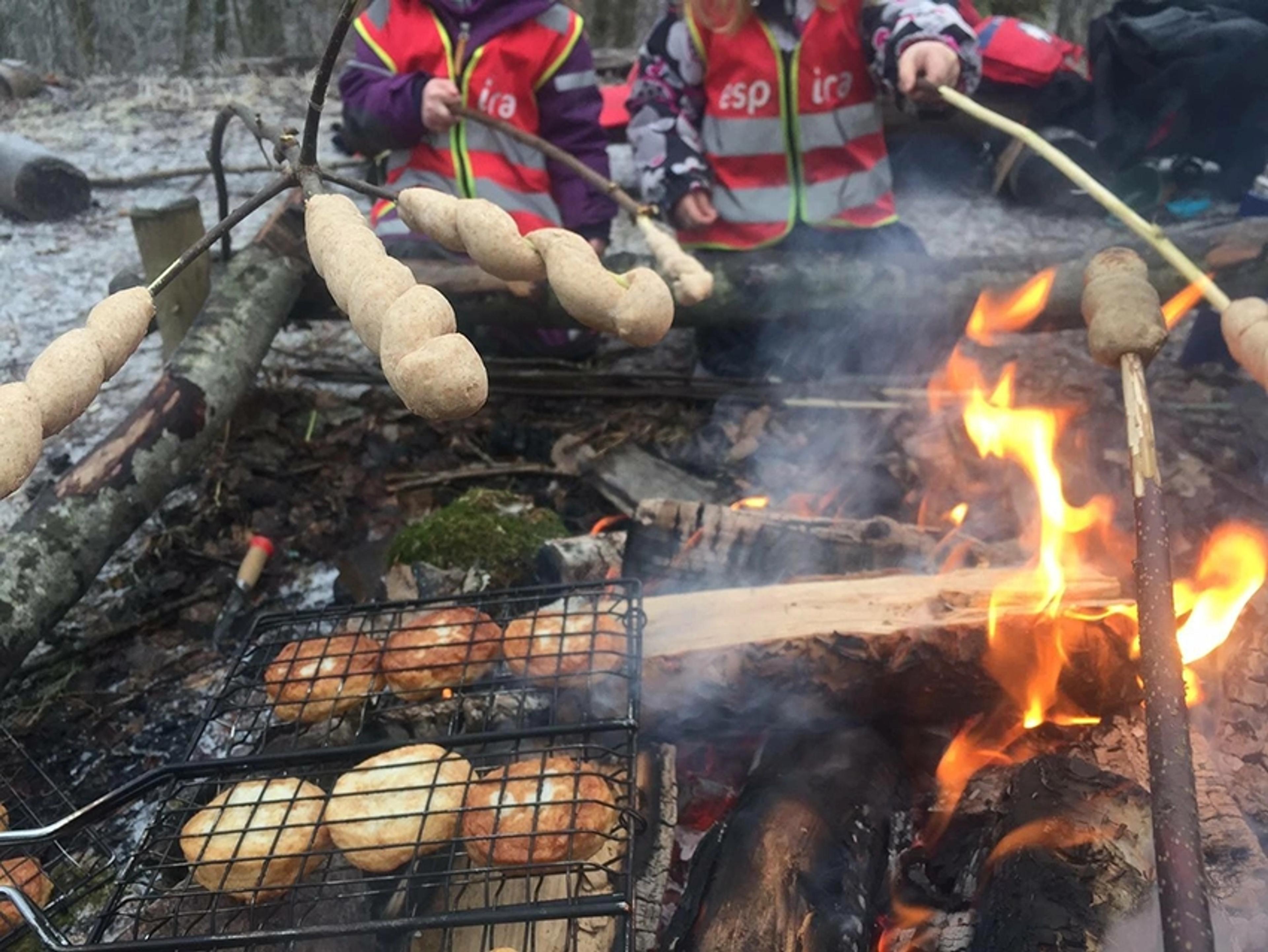 Barnehagebarn i Espira Eikenga lager mat på bålet - pinnebrød og fiskekaker