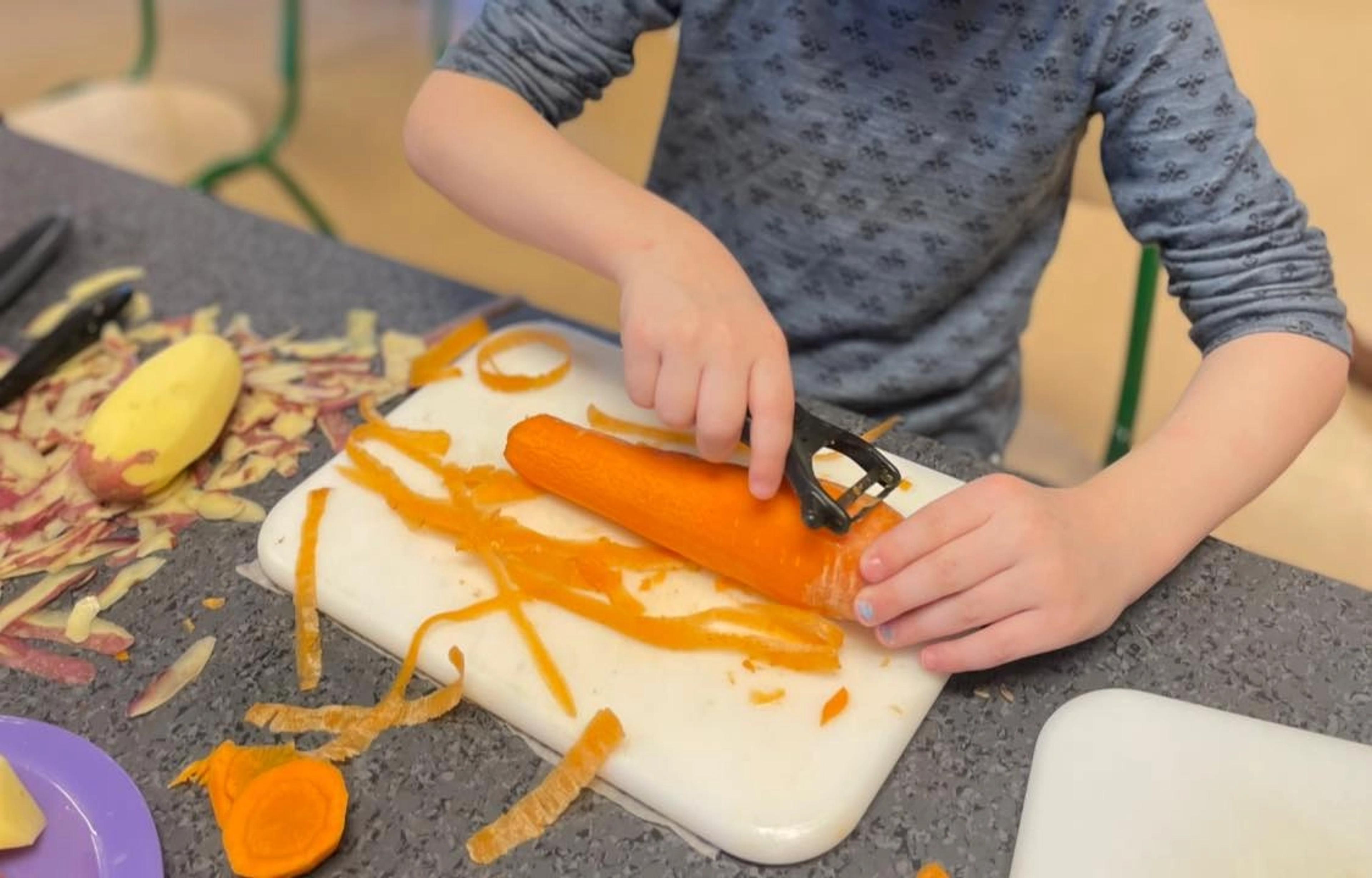 Barn som skreller gulrot i Espira Nordmo