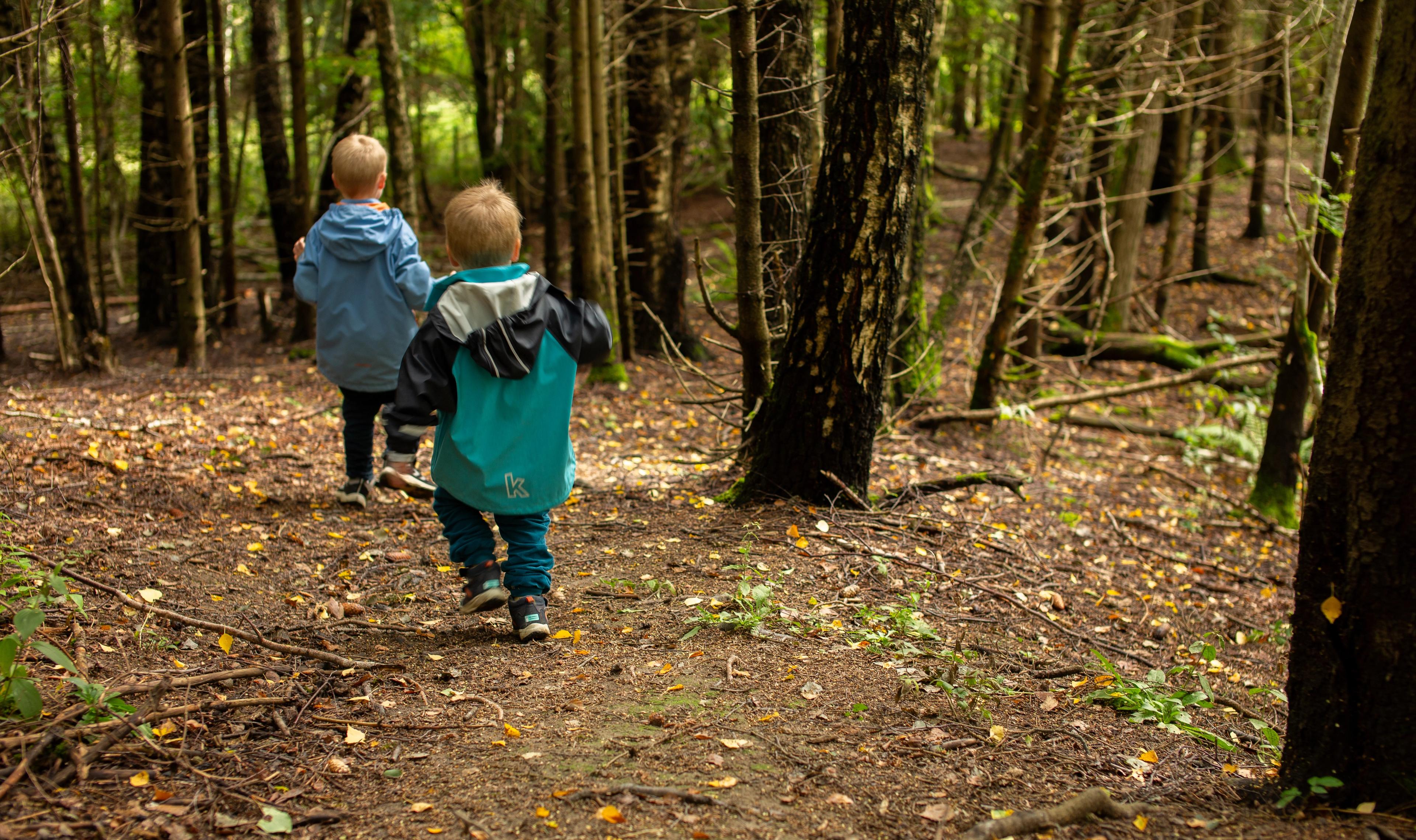 To barn som løper i skogen