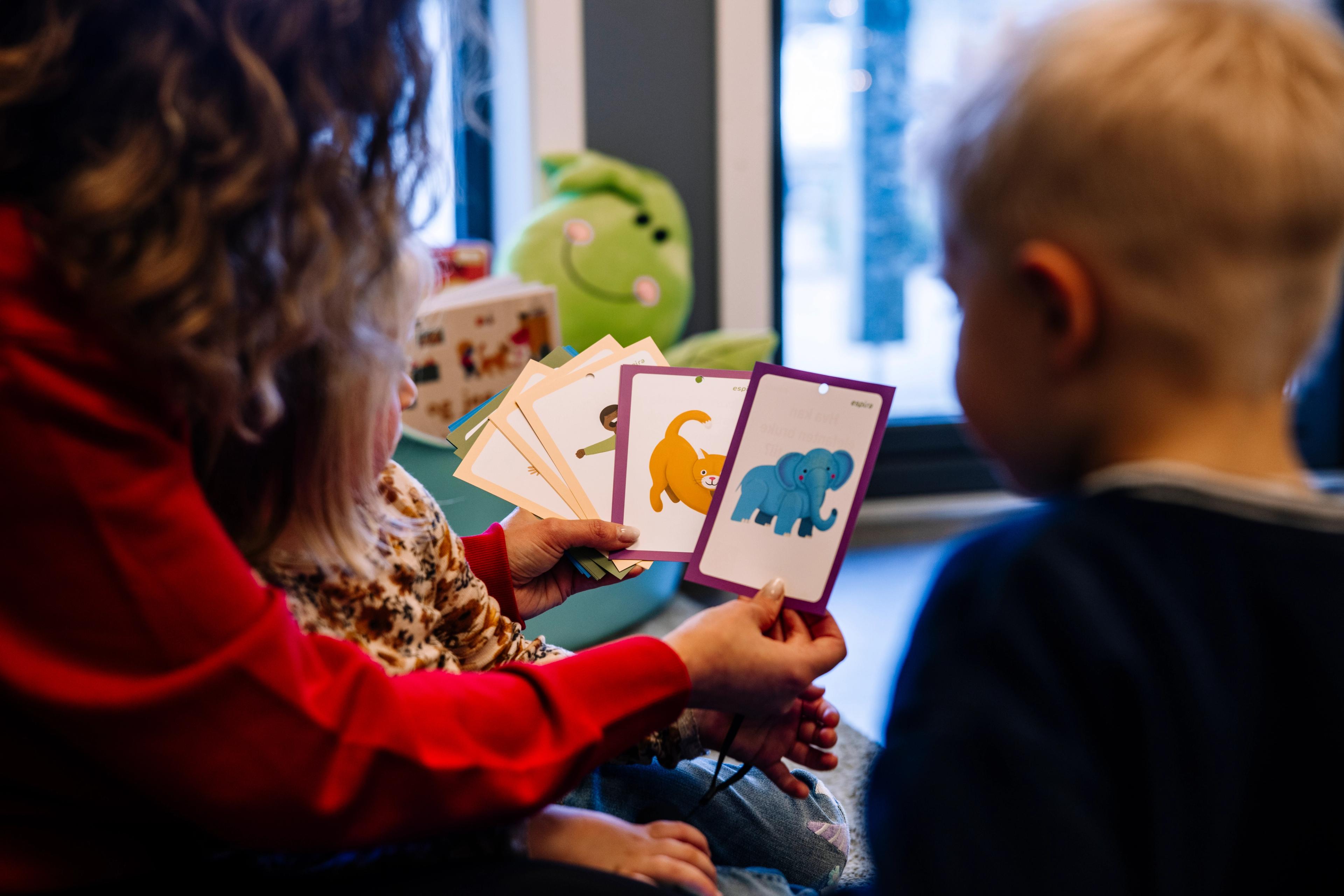 Barn som sammen med en voksen utforsker språk ved hjelp av språkkort - Espira barnehage