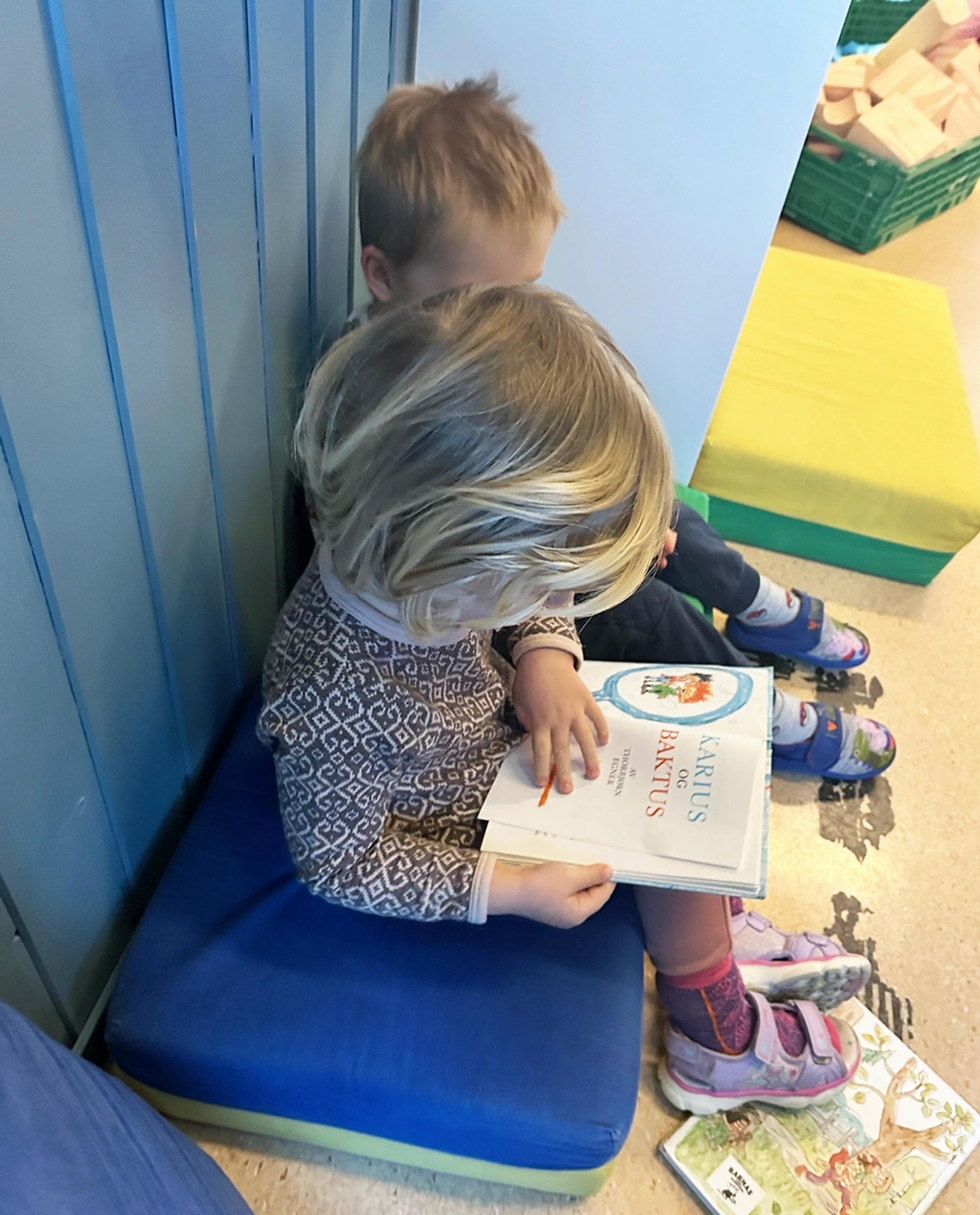 Barn som leser bok sammen i Espira Torsbergskogen