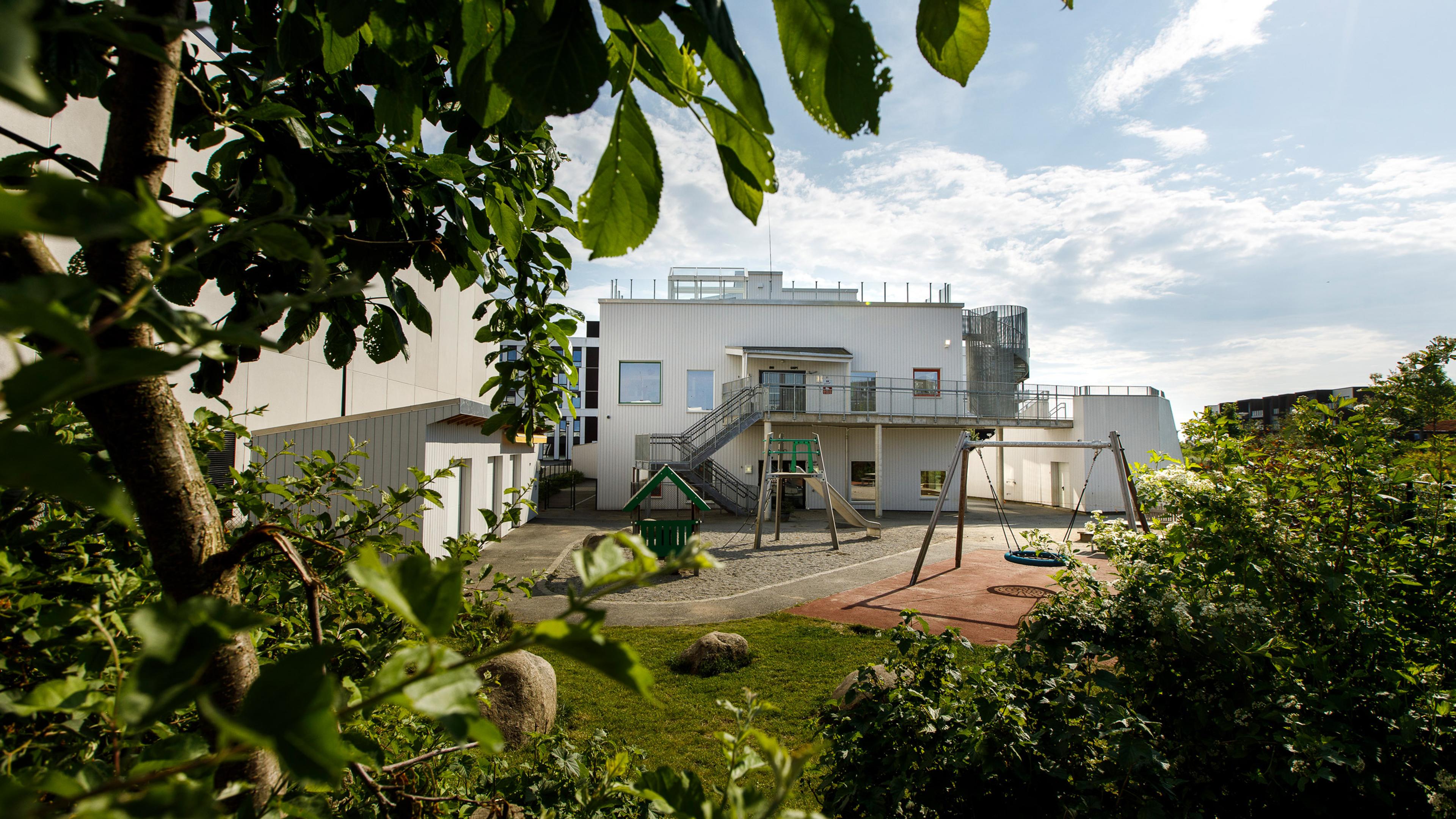 Espira Tastarustå i Stavanger kommune - hvit fasade og grønt lekeområde