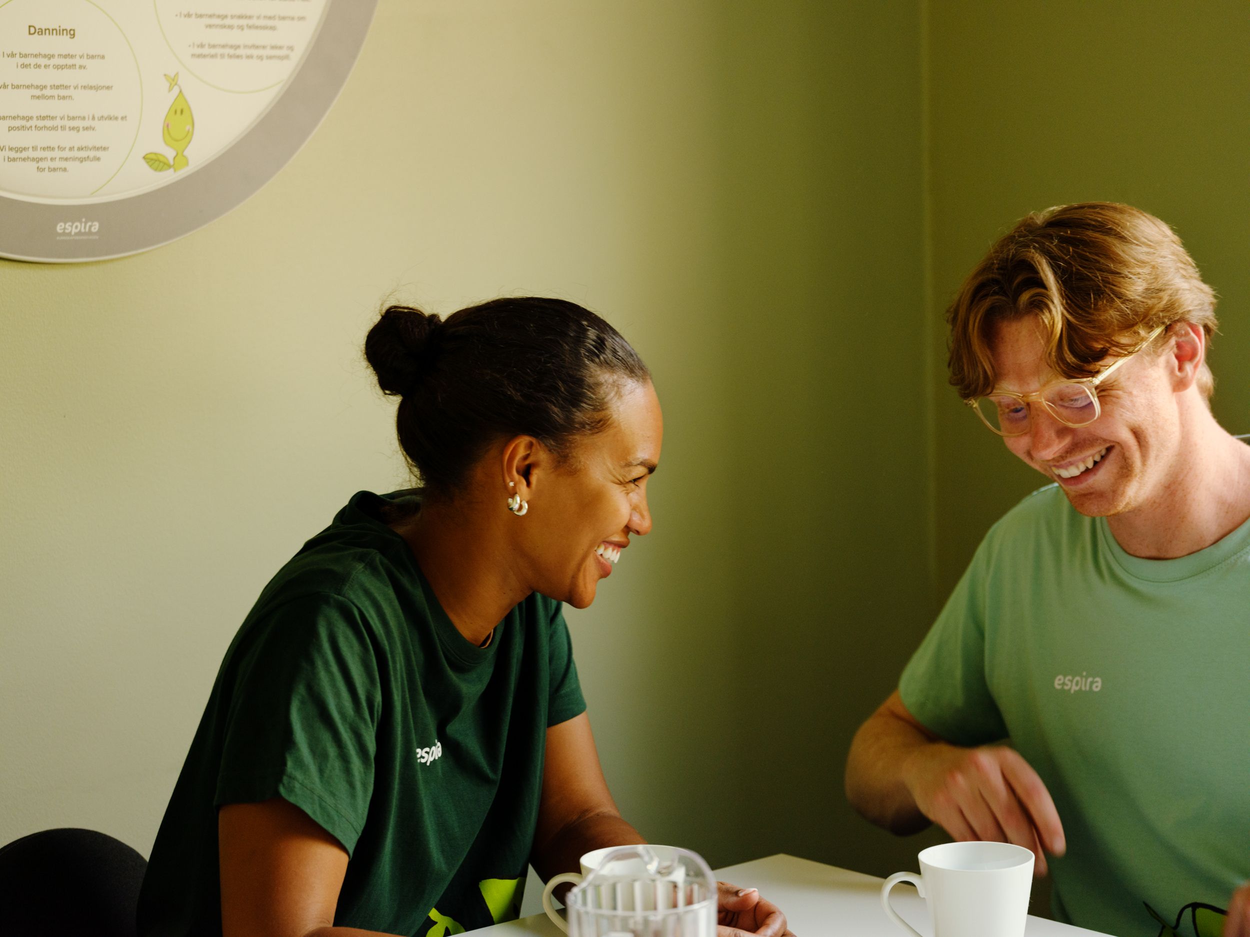 a man and a woman are sitting at a table laughing .