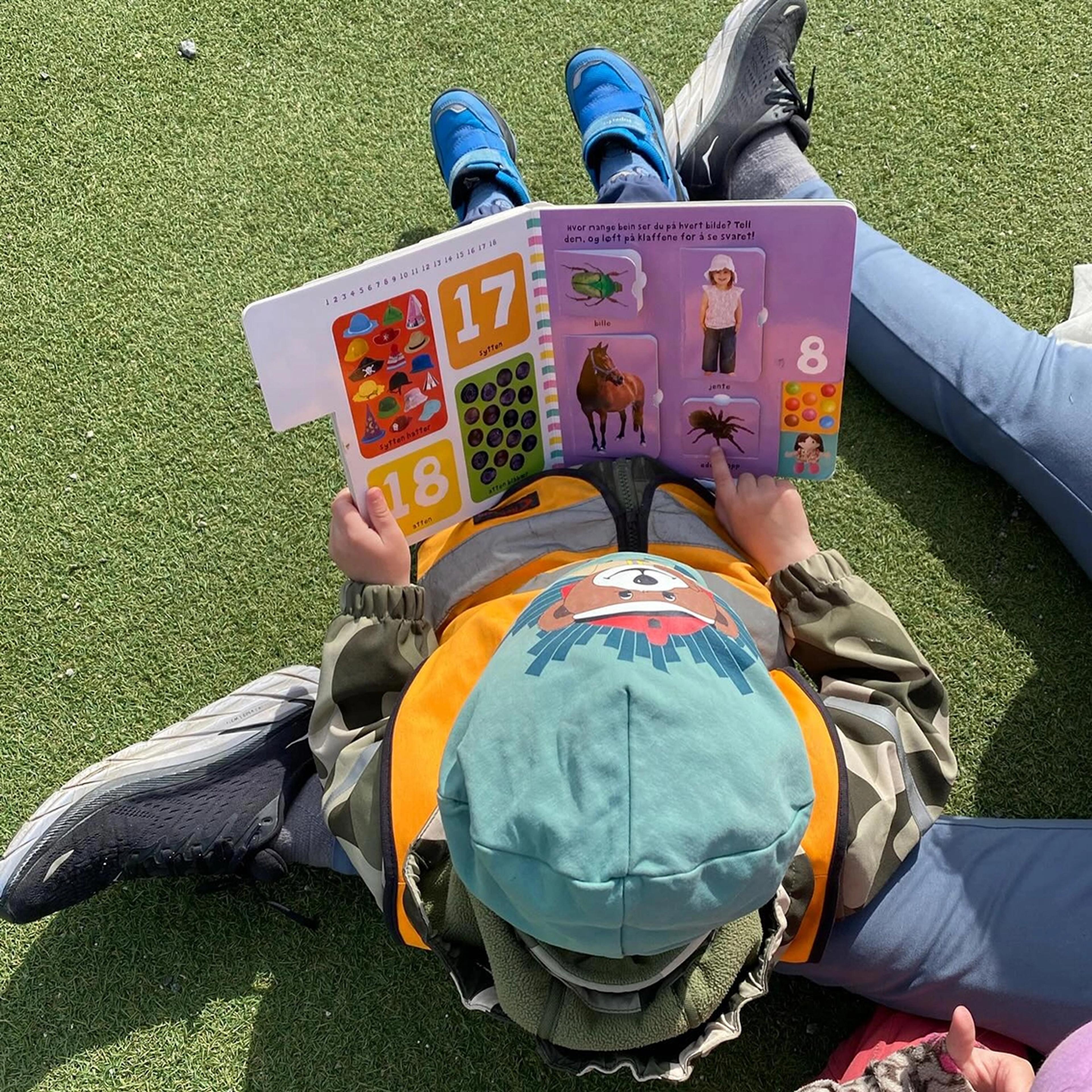 Barn som leser bok ute i Espira Ulvenvatnet