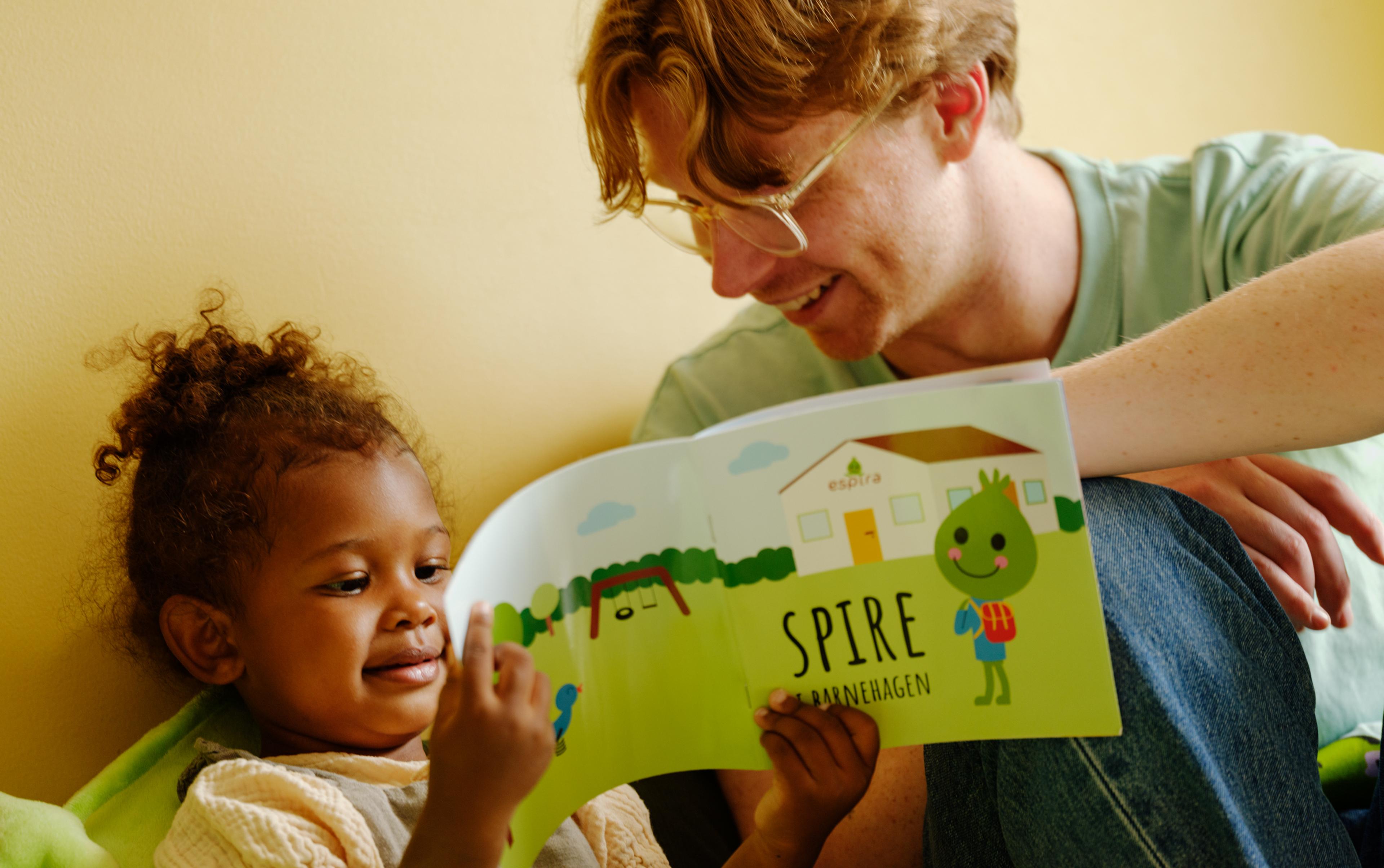 a man is reading a book to a little girl .